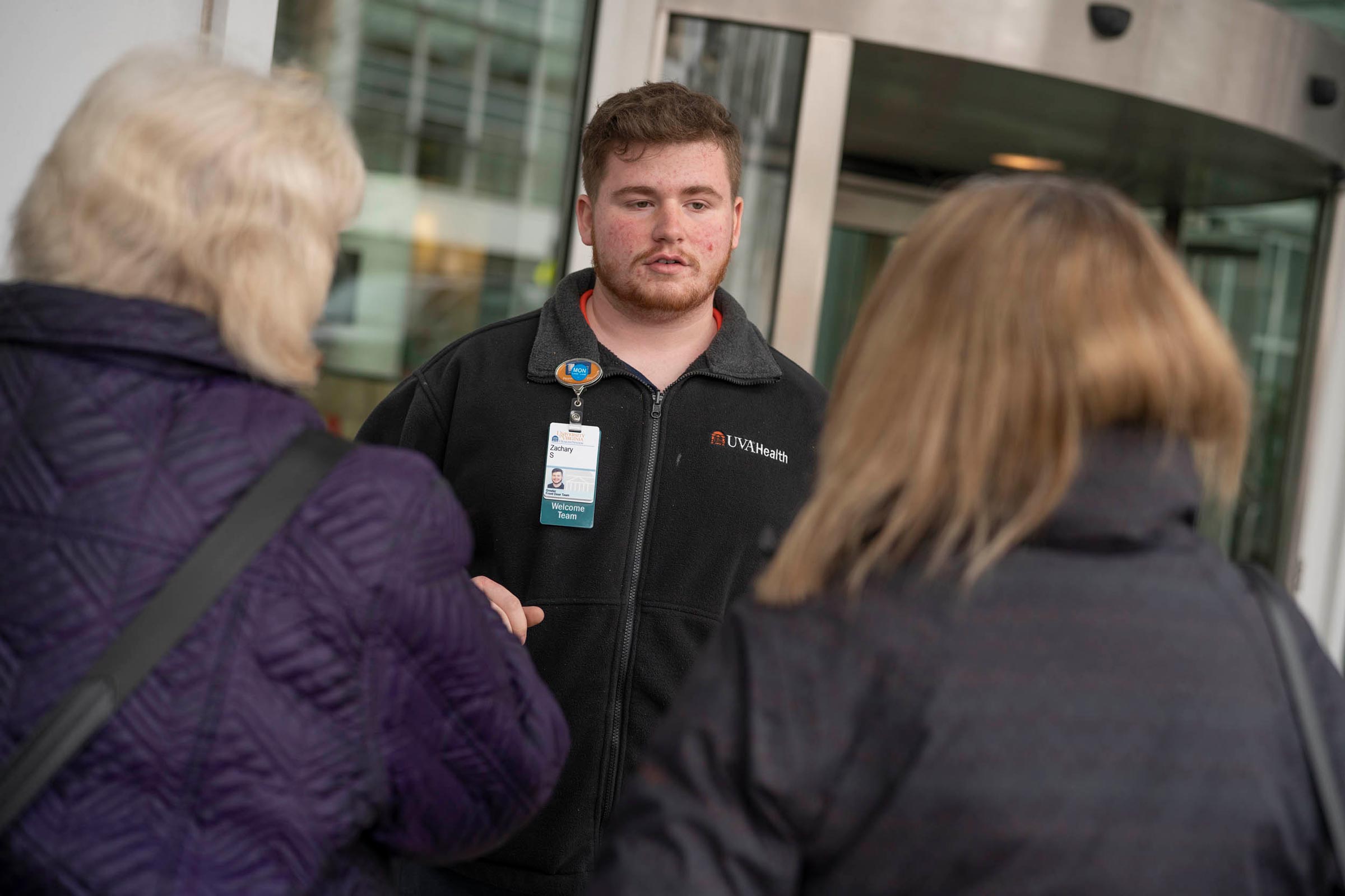 UVA Health member talking to people before entering the Hospital