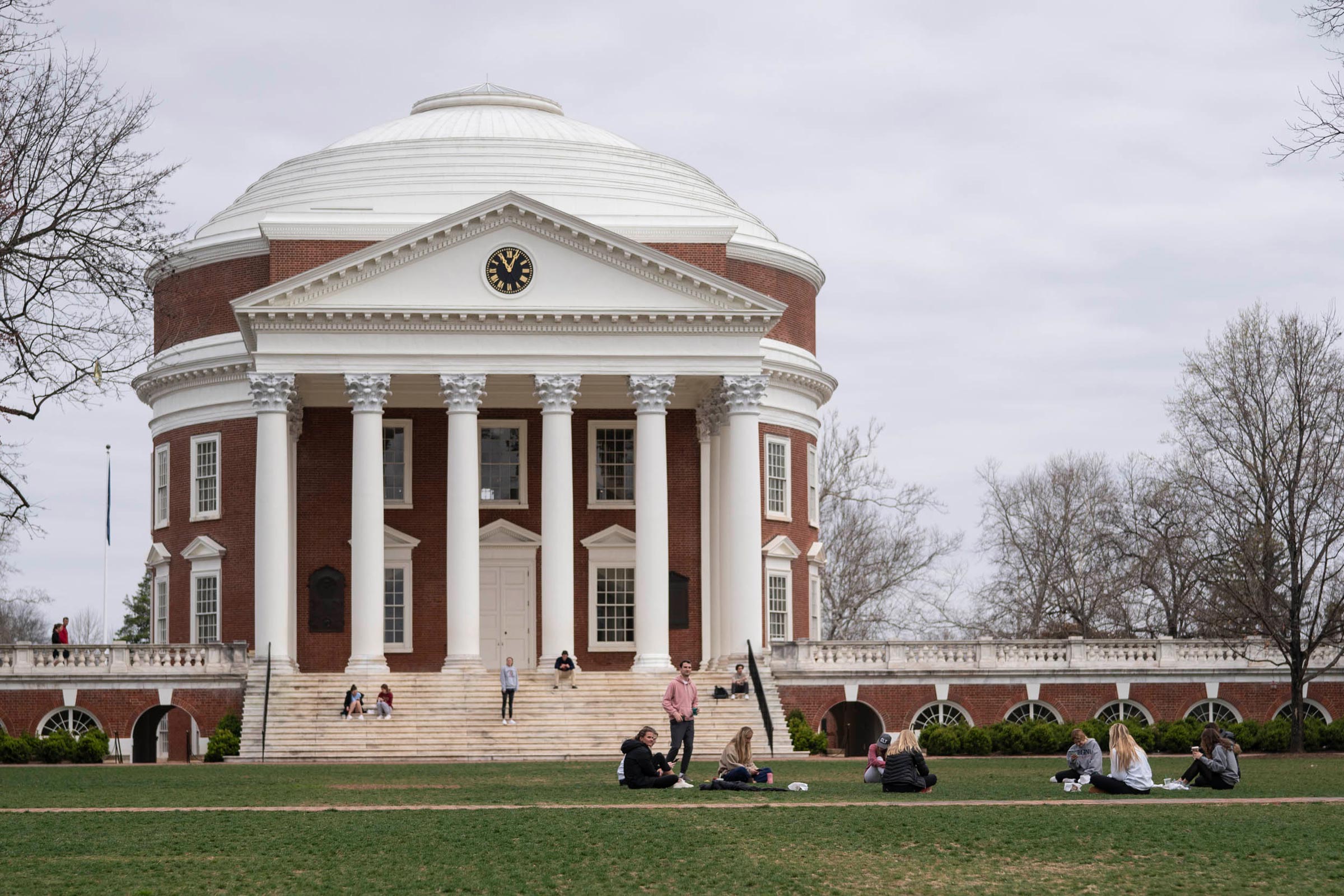 People sitting in front of the Rotunda on its steps and Lawn