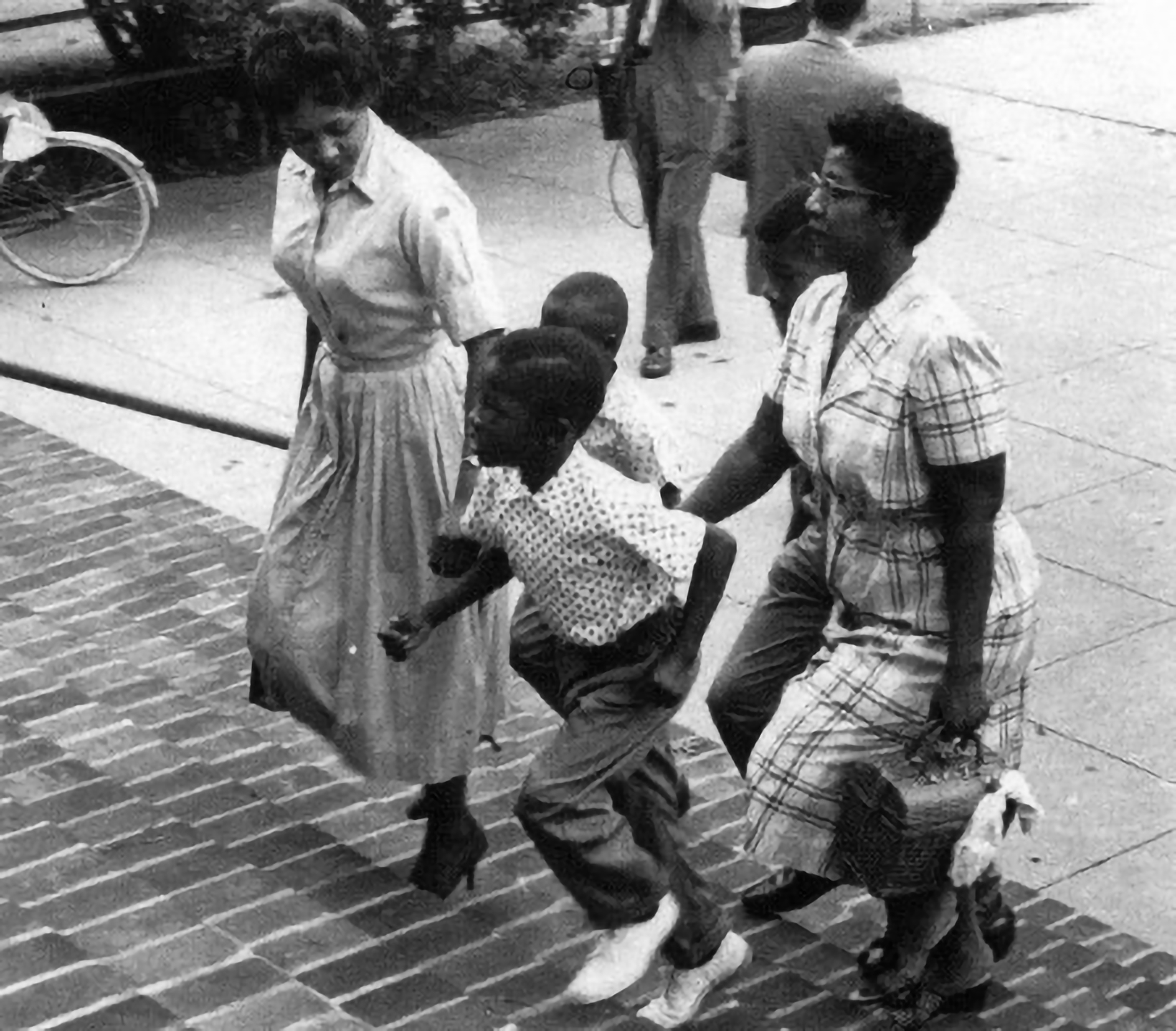 African American woman and children walking up the steps to their school