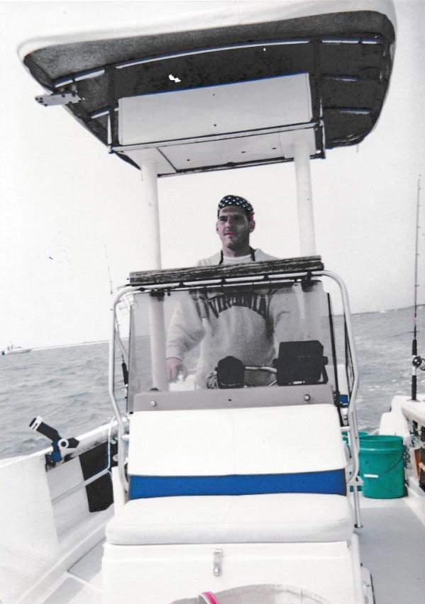 Black and white image of Murphy driving a boat