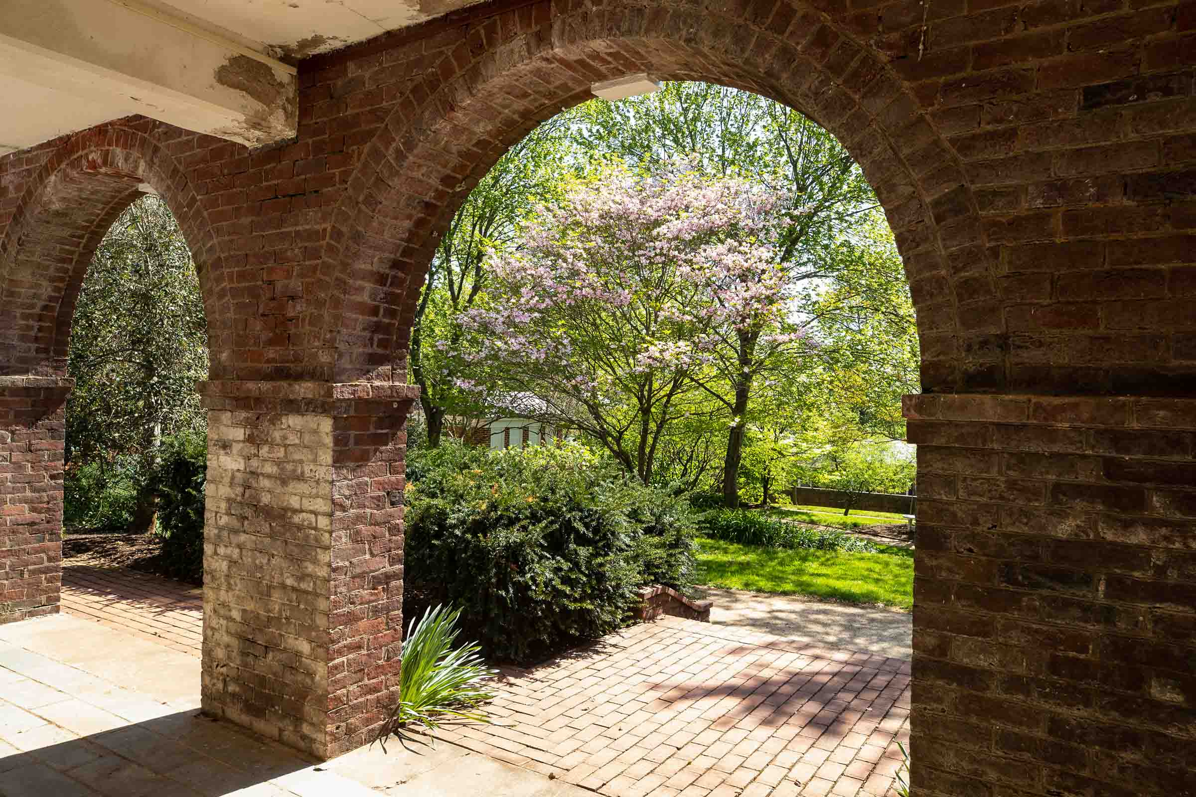 Brick Arched way looking into a flowering garden