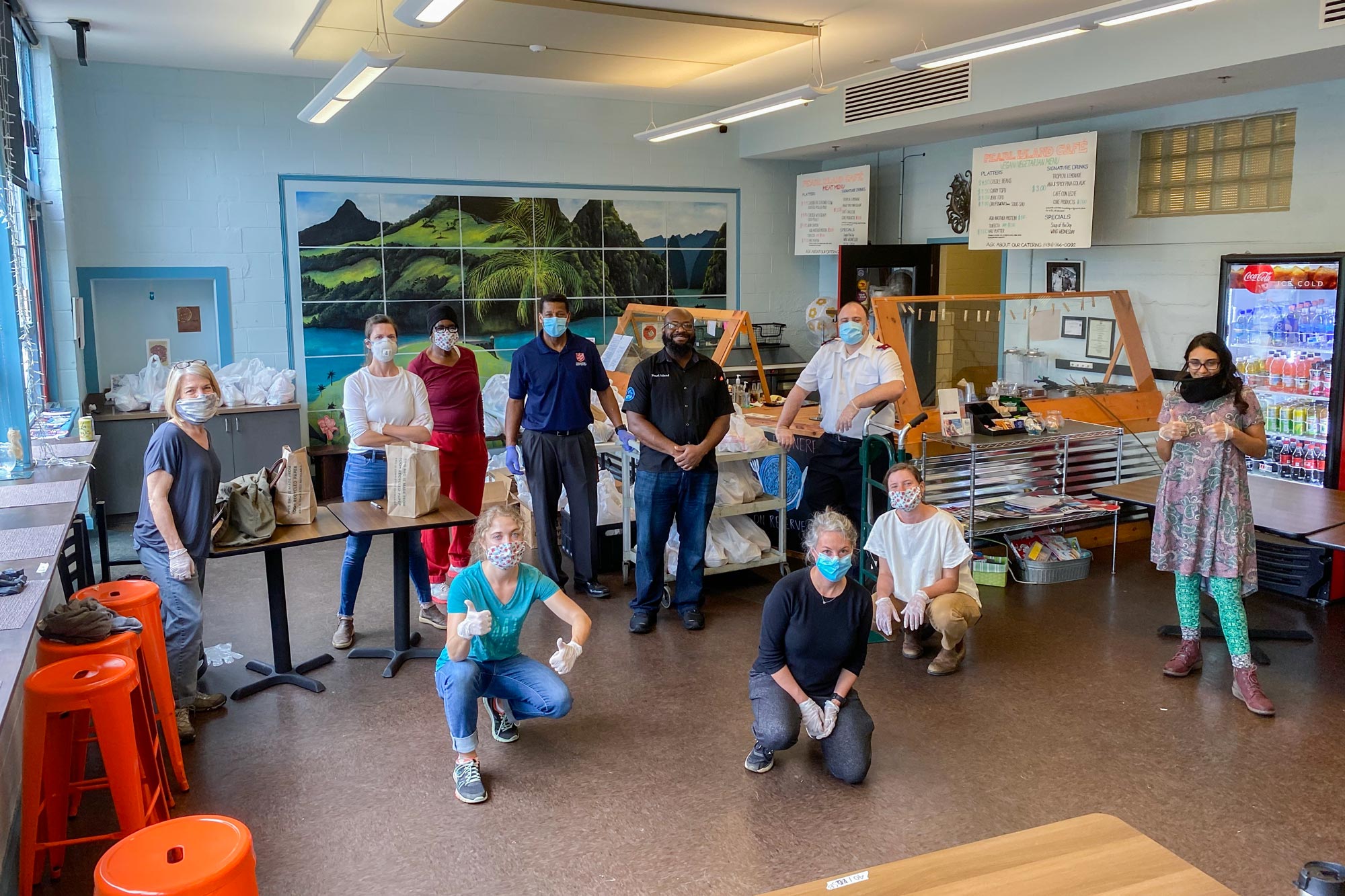 Volunteers social distance for a picture while they are packing food bags