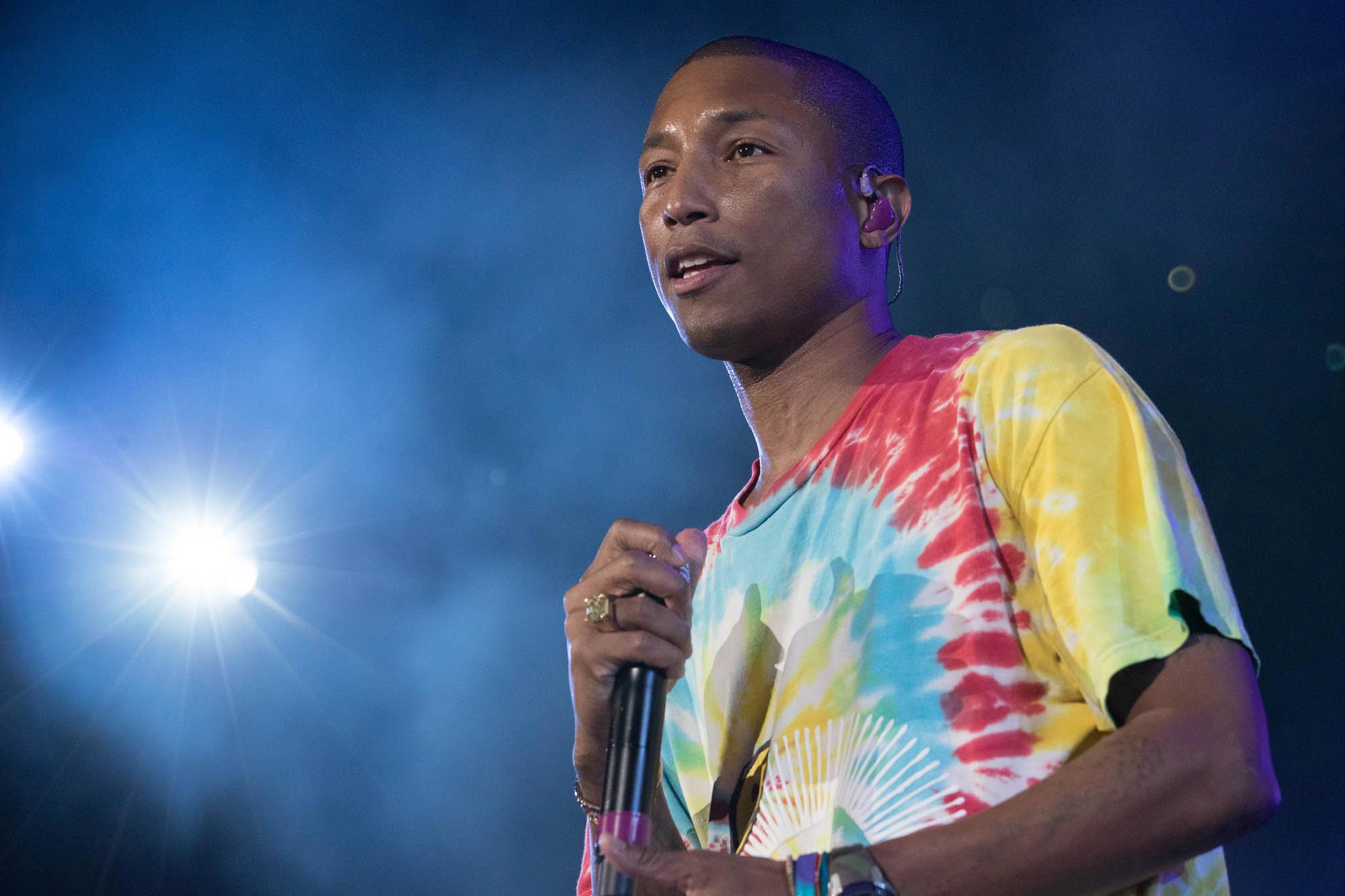 Pharrell Williams holding a microphone on stage