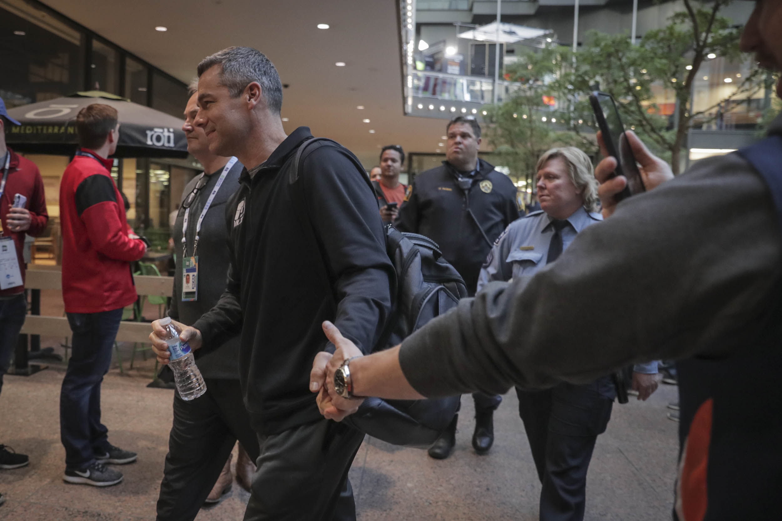 Coach Tony Bennett makes his way to the team bus while shaking hands of fans