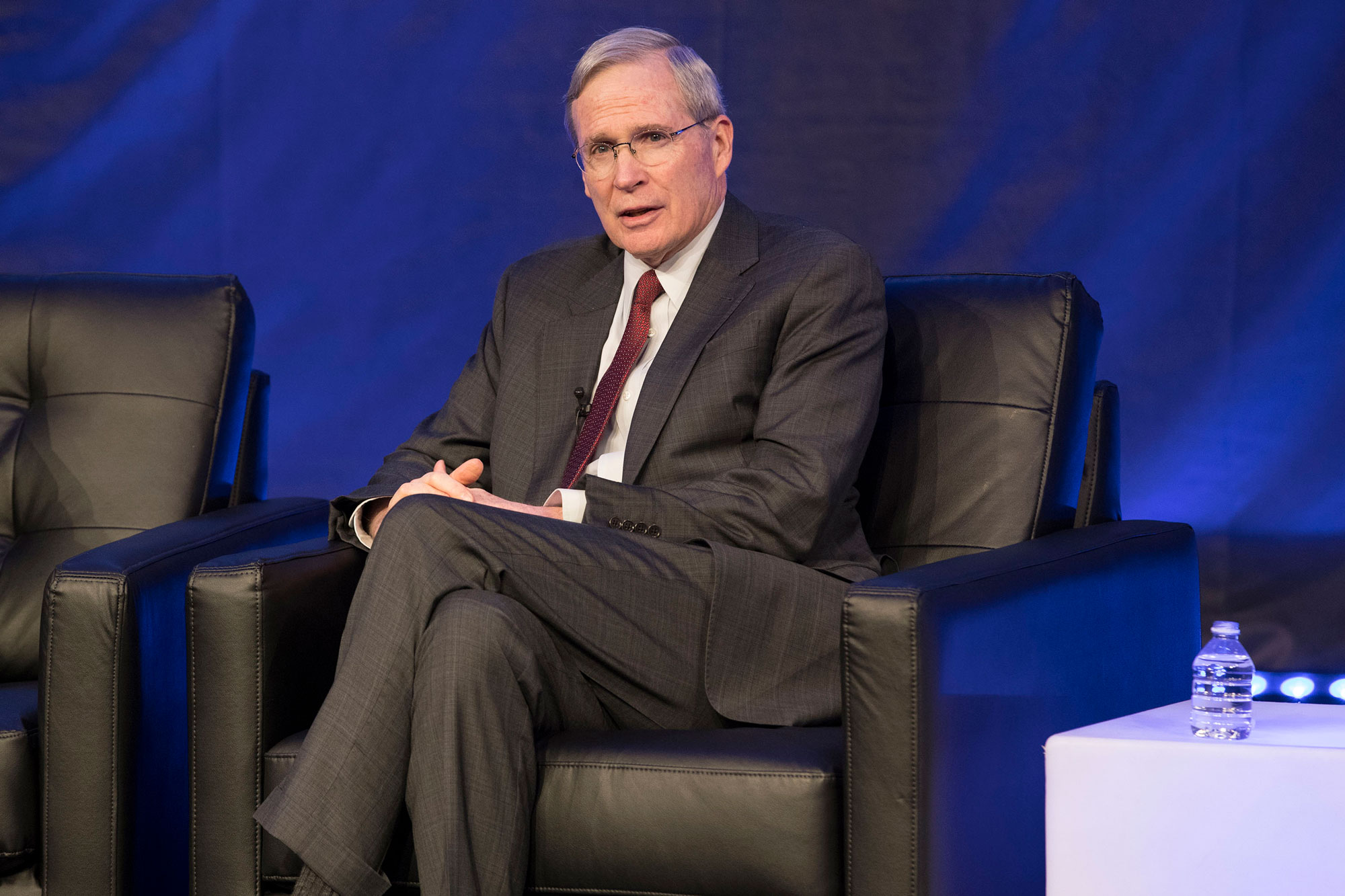 Stephen Hadley talking on stage in a black leather chair