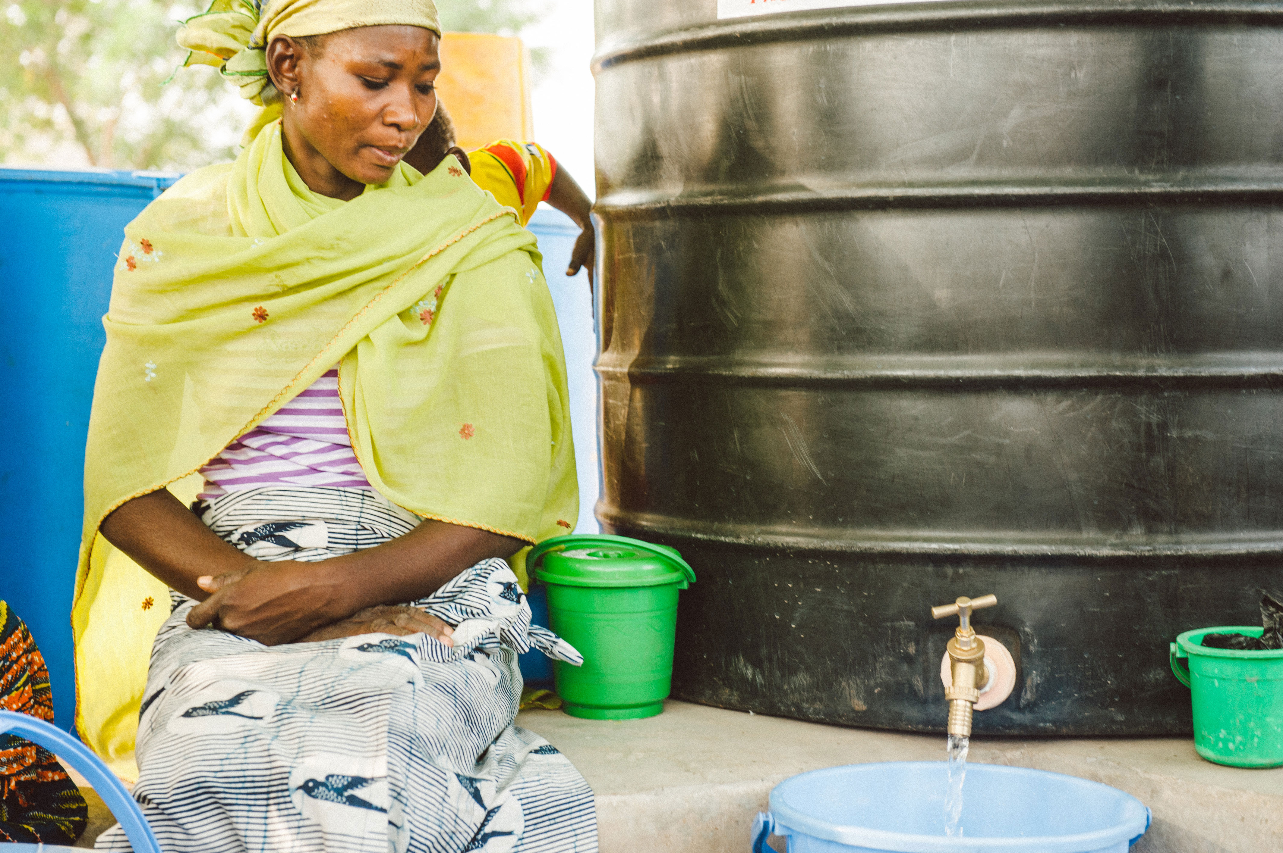 Families bring the safe storage containers provided by Saha Global to fill them with the water that has been purified by local Ghanaian entrepreneurs.