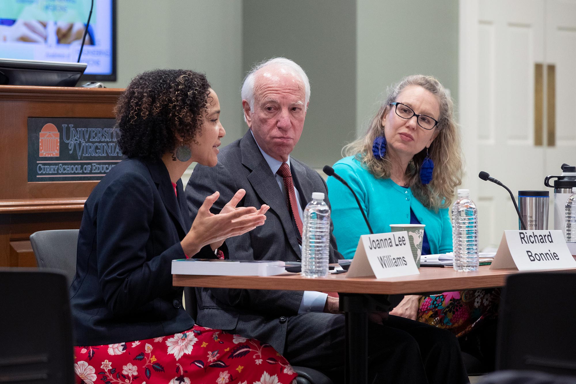 Nancy Deutsch, right,  Richard J. Bonnie, middle, and Joanna Lee Williams, left, sit at a table during a panel discussion