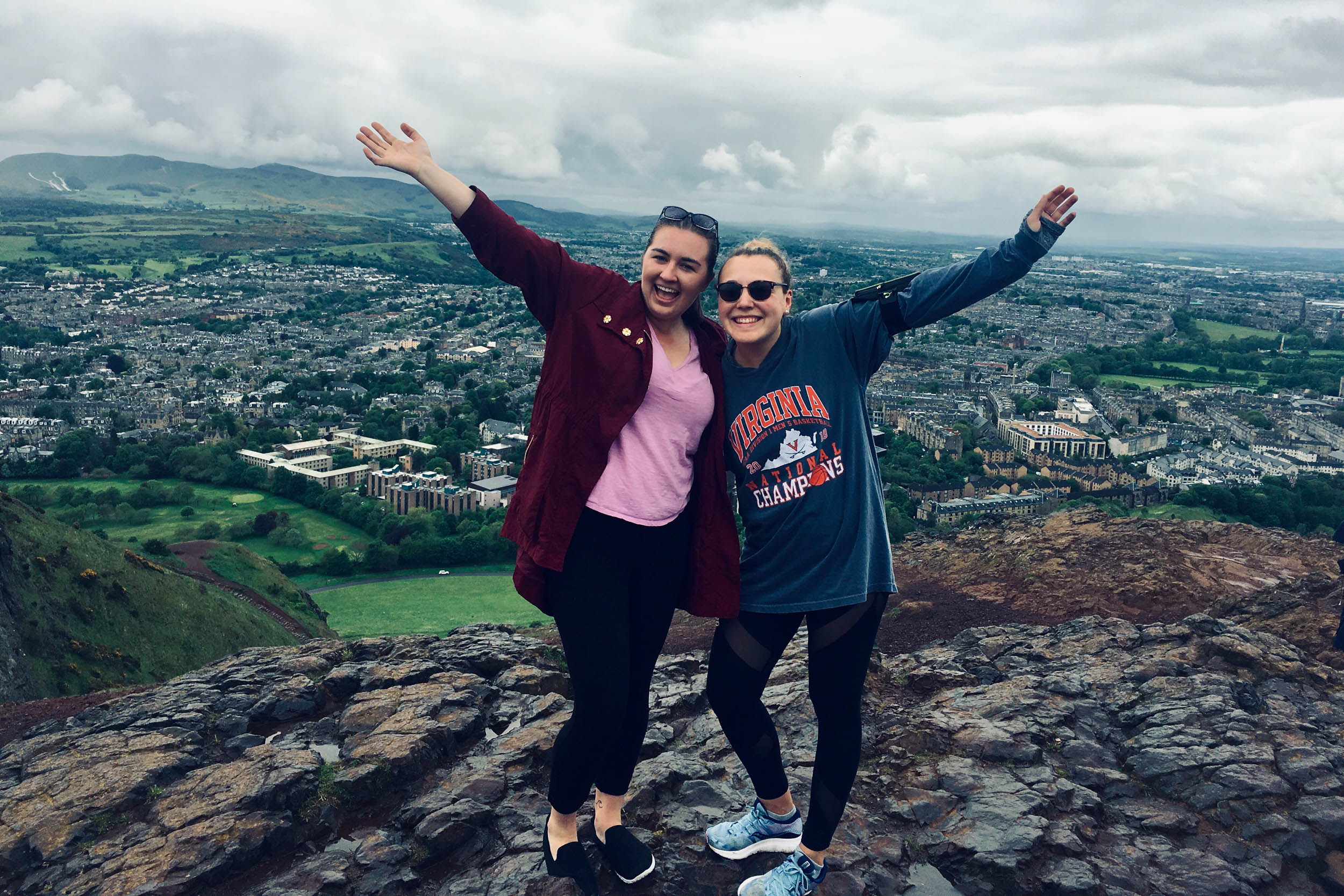 Emily Davenport stands next to a colleague at the top of Arthur’s Seat in Scotland. 