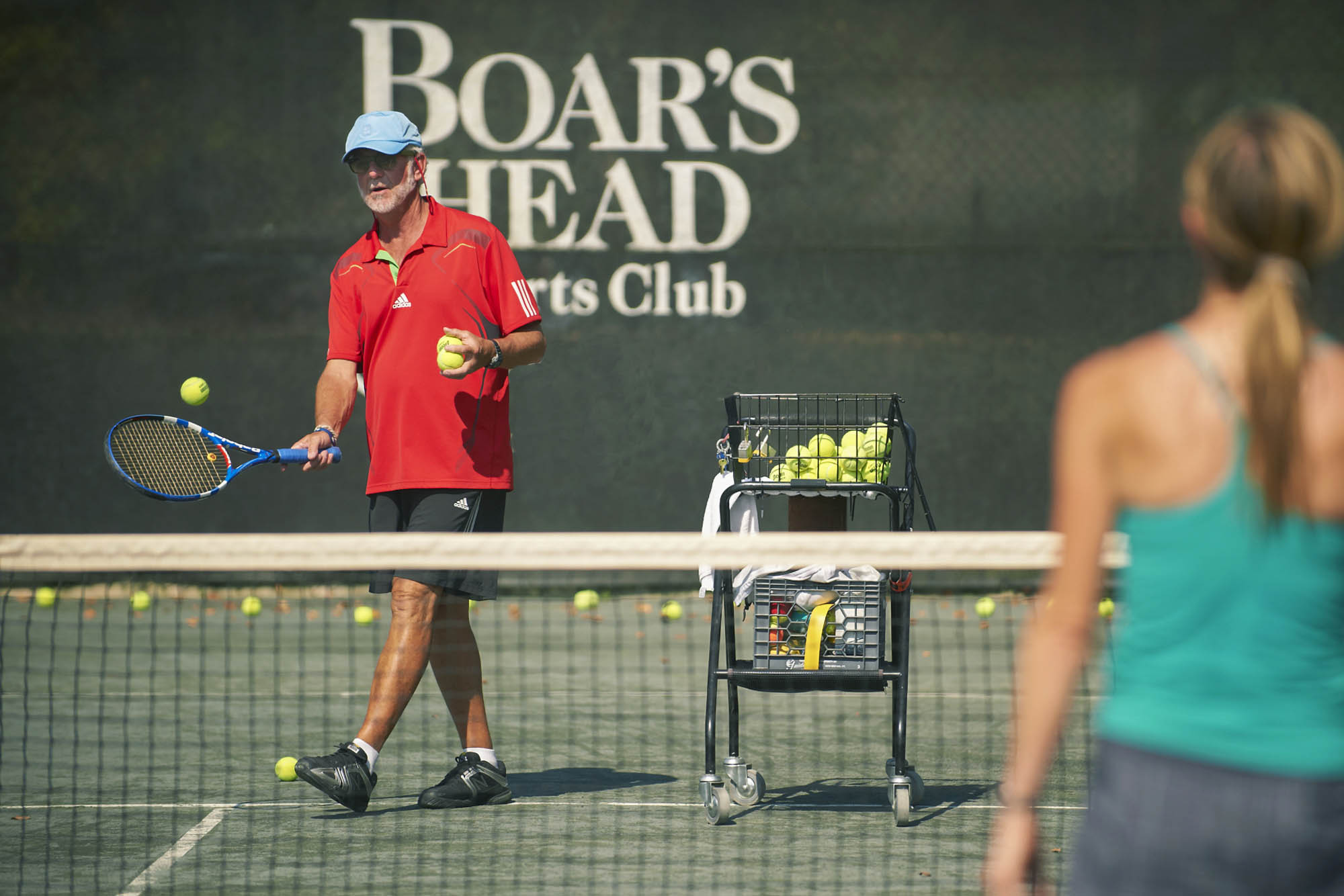 Manilla hitting a tennis ball at the Boar's Head tennis court