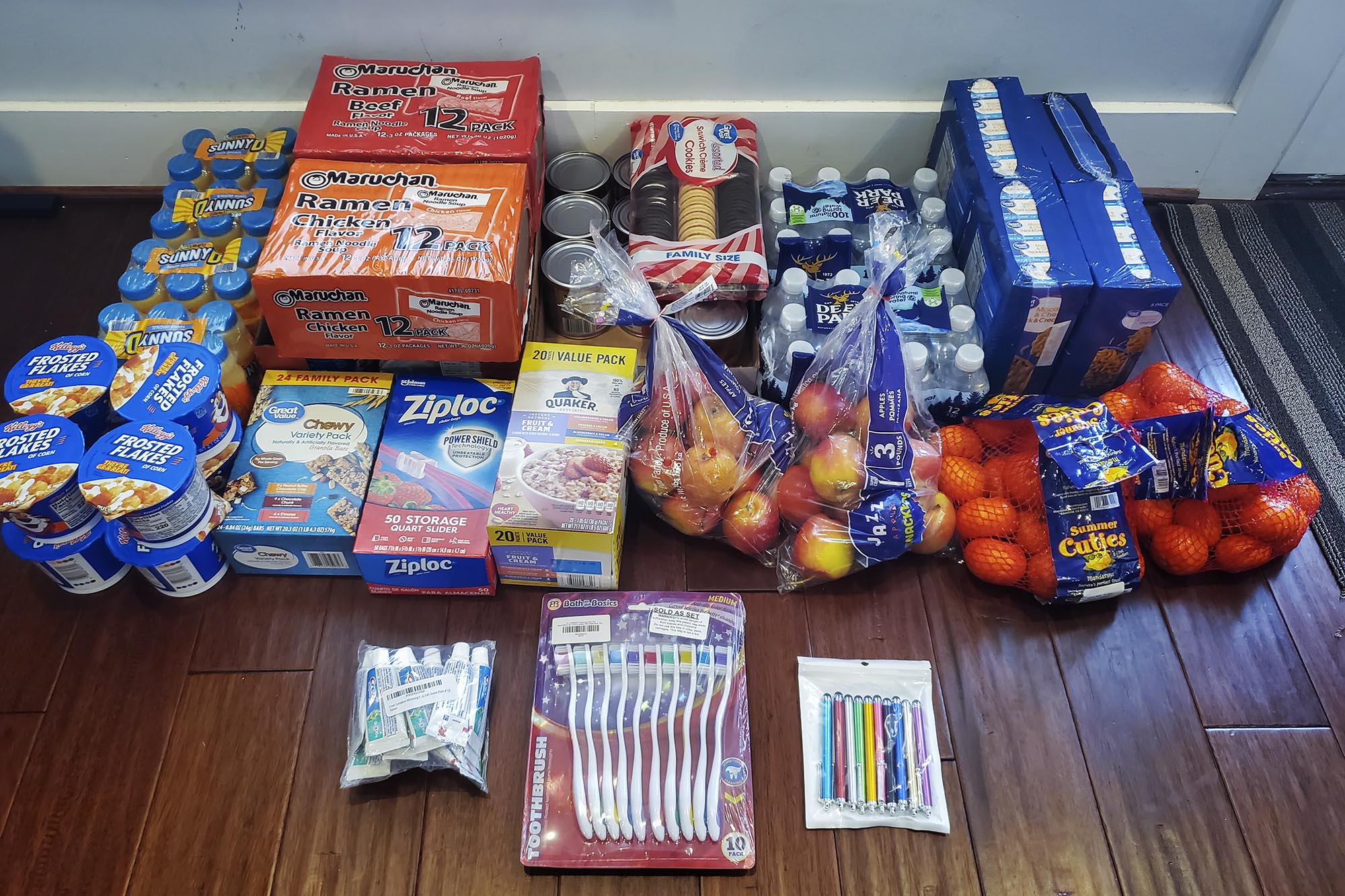 Various food and hygiene supplies sorted on the floor