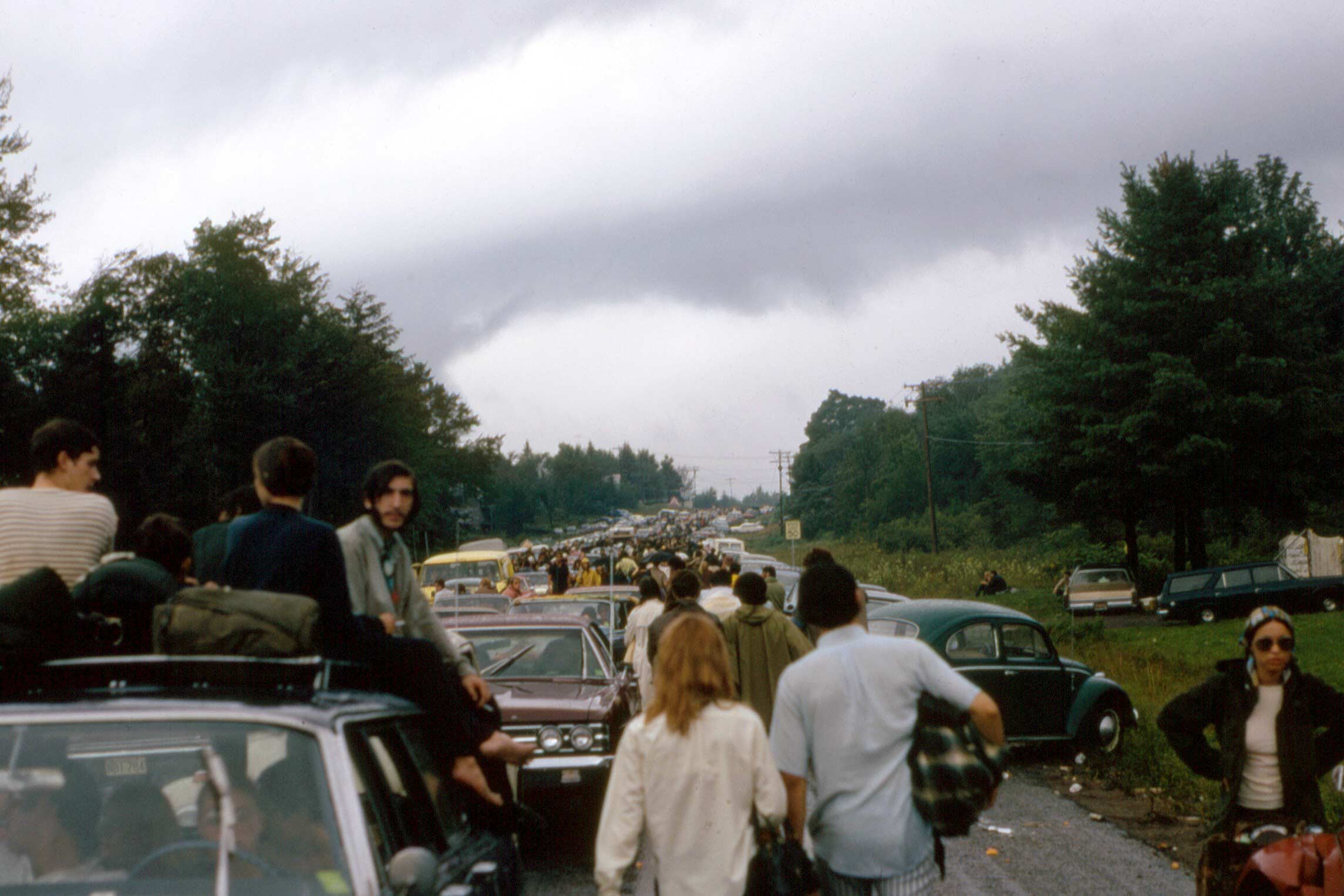 Line of traffic with people walking on the road going to woodstock