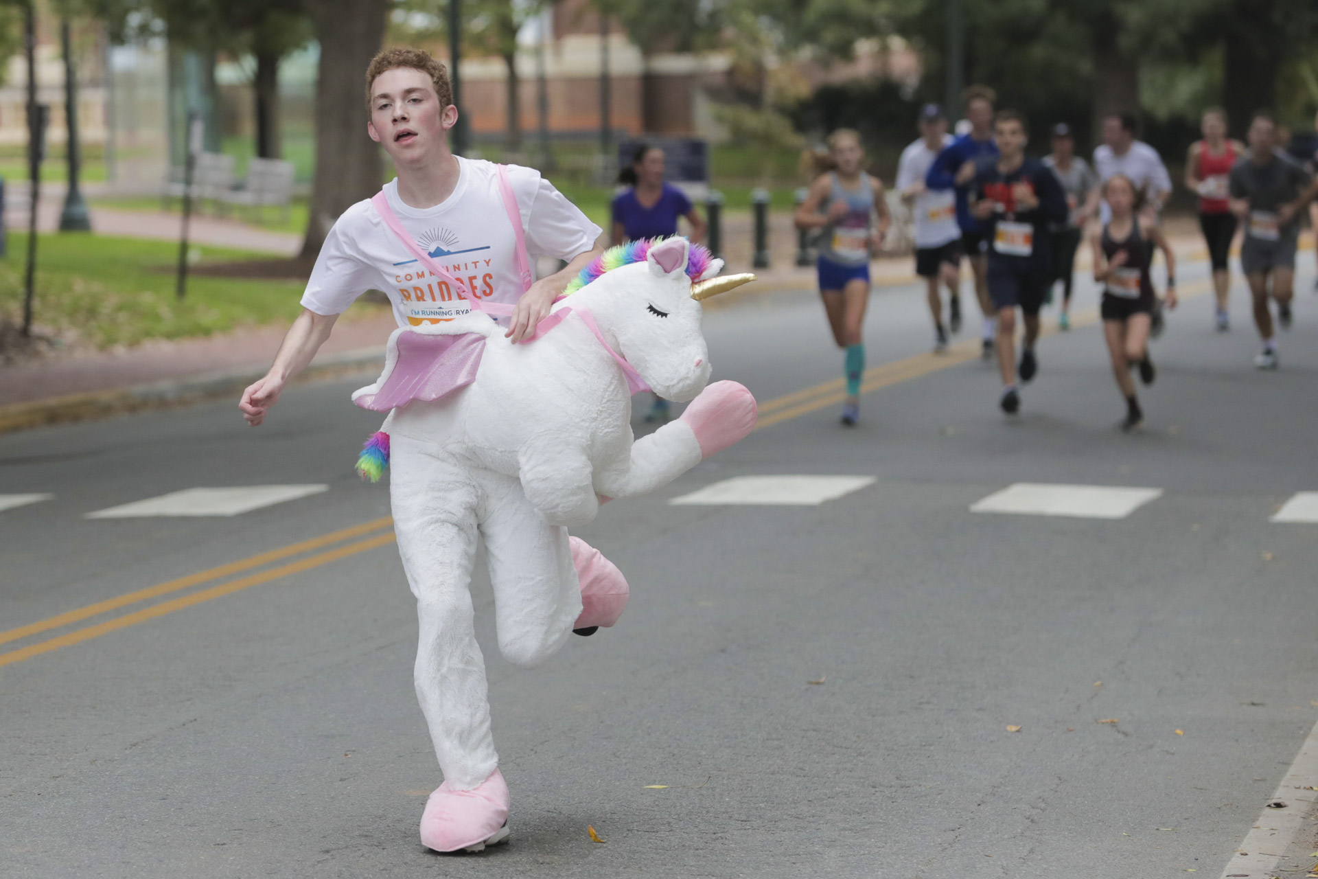  Man dressed in a unicorn runs down the road