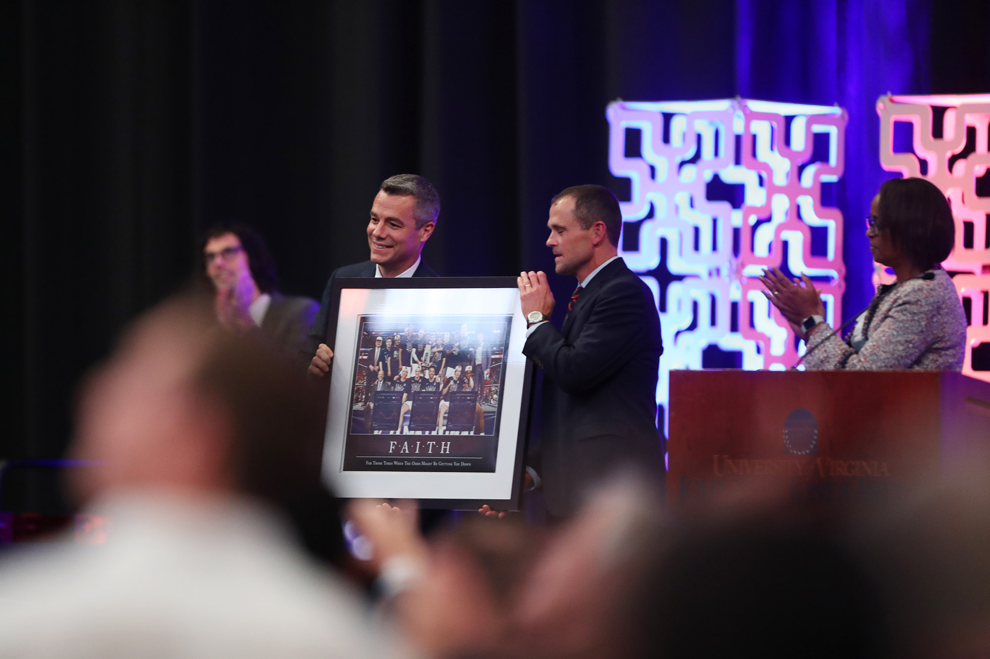 Jim Ryan and Tony Bennett hold a picture together on stage