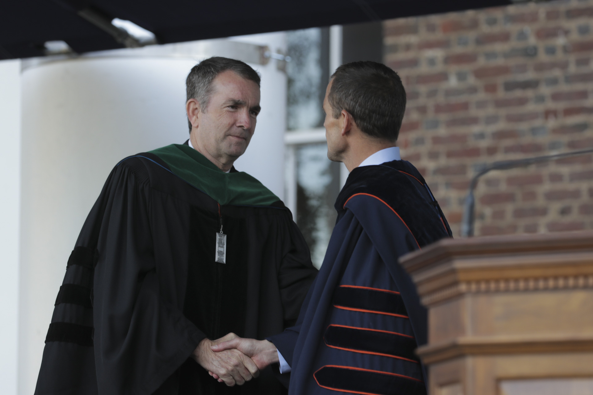 Governor Ralph Northam stands up to shake Jim Ryans hand