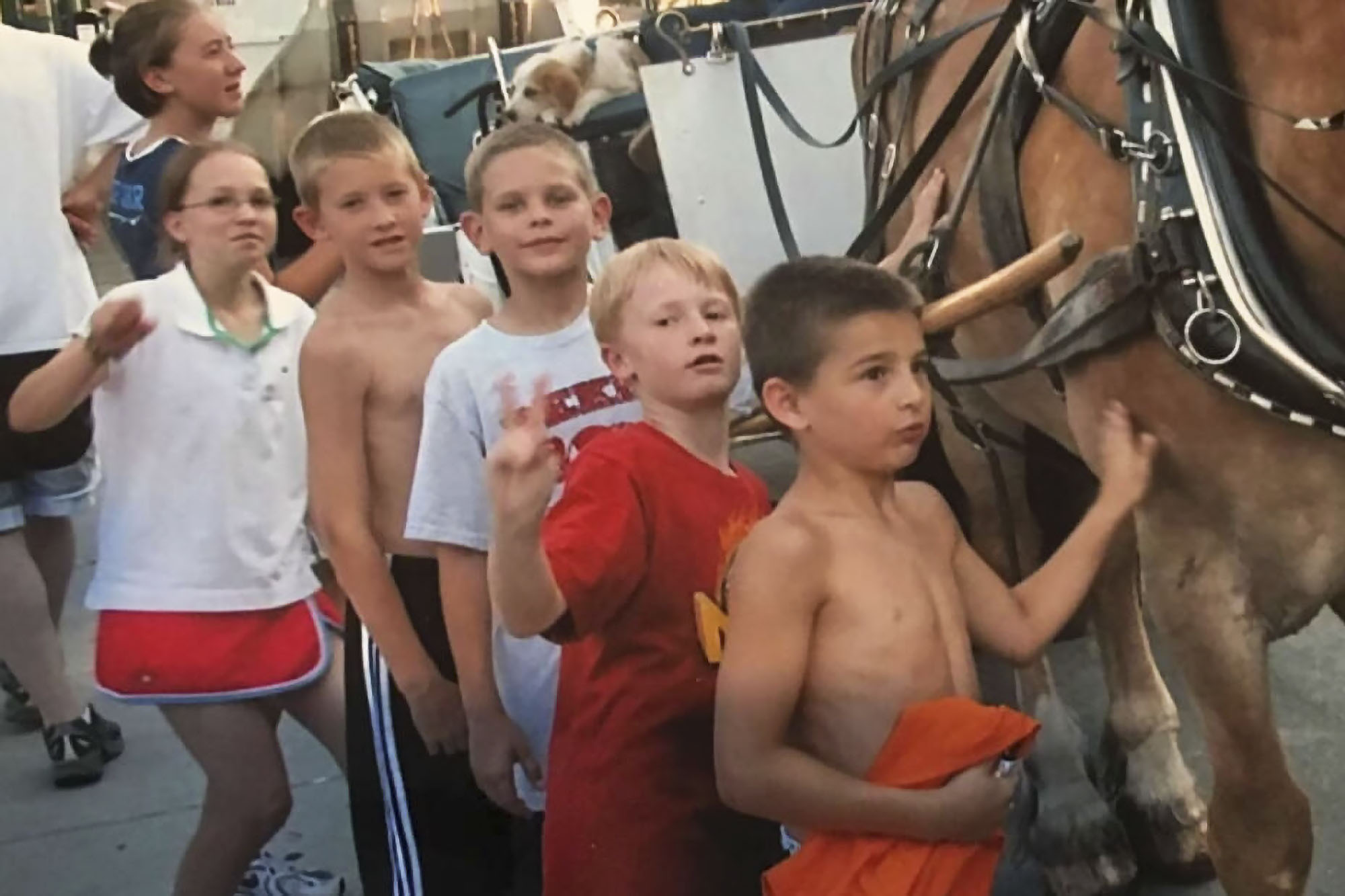 Sam Hauser and Ben Vander Plas (second and third from left) in line when they were children touching a horse