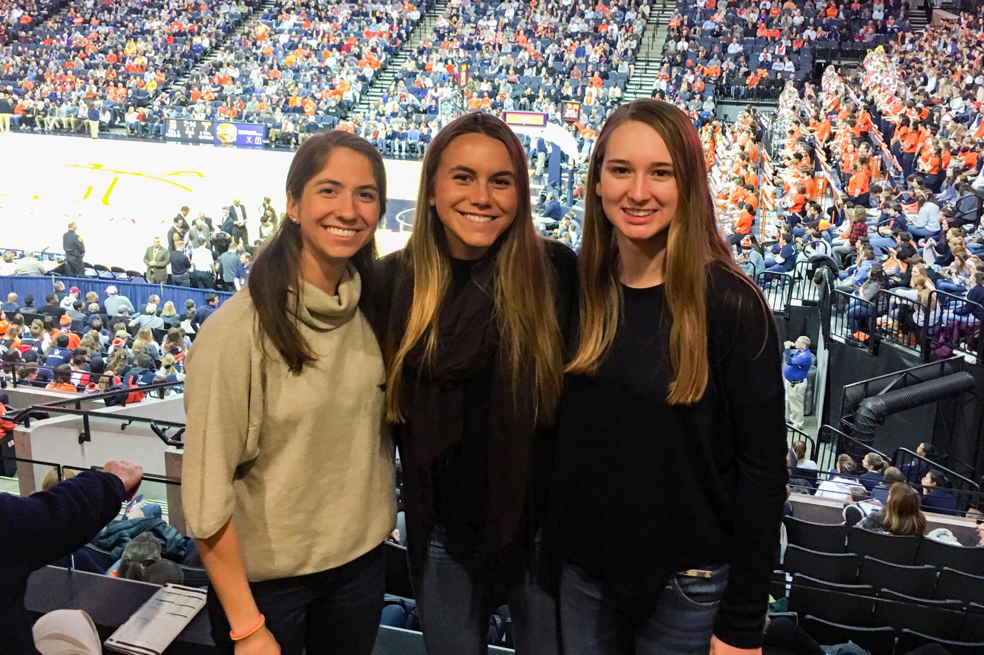 Doss, right, Annie Tyson, left, and Elle Carroll, take a photo together at a basketball game