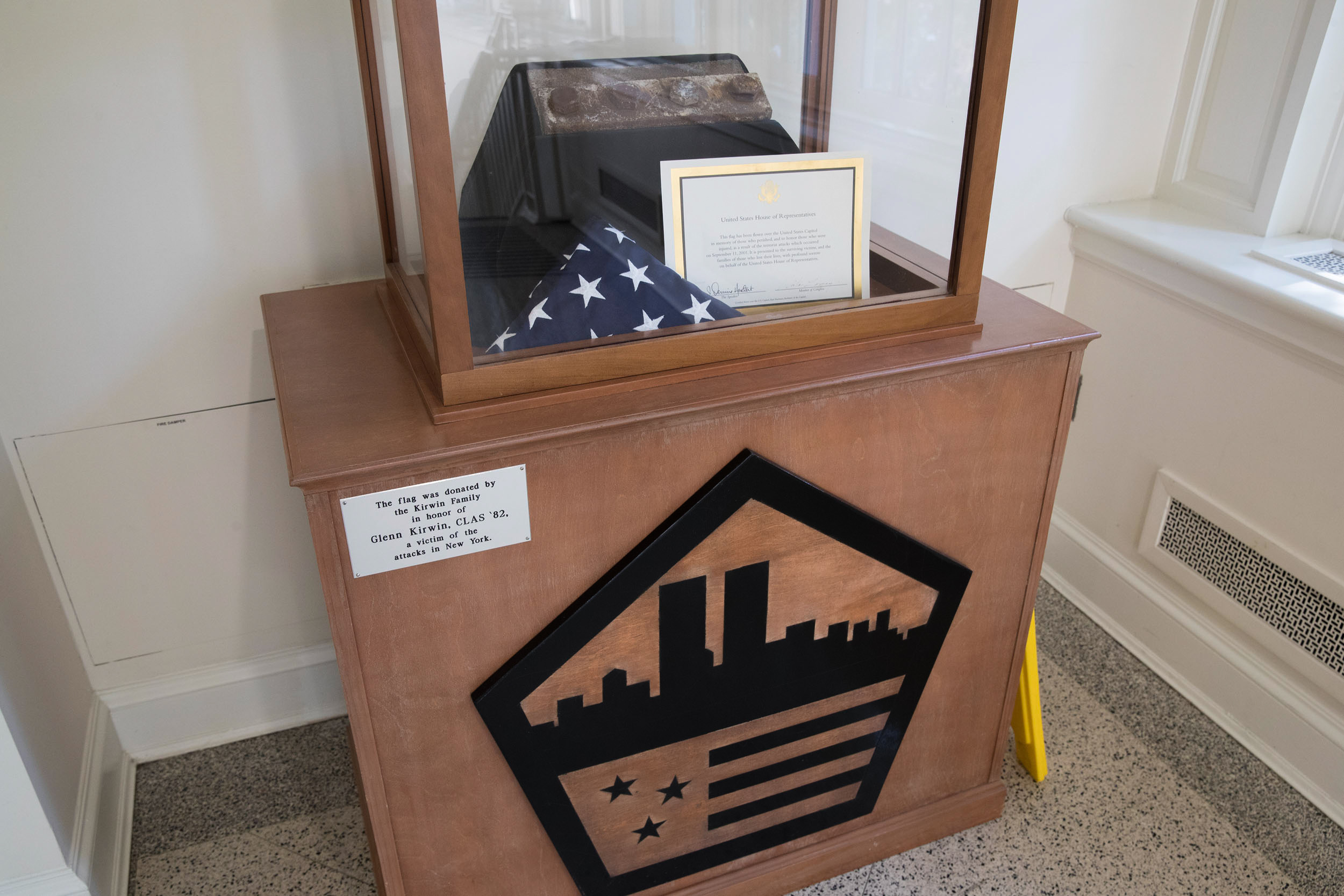 American flag and a piece of steel in a glass box