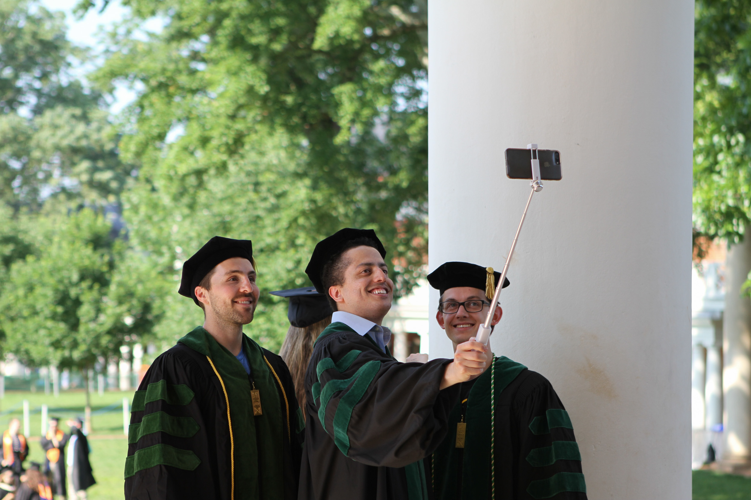 Graduates using a selfie stick for a picture