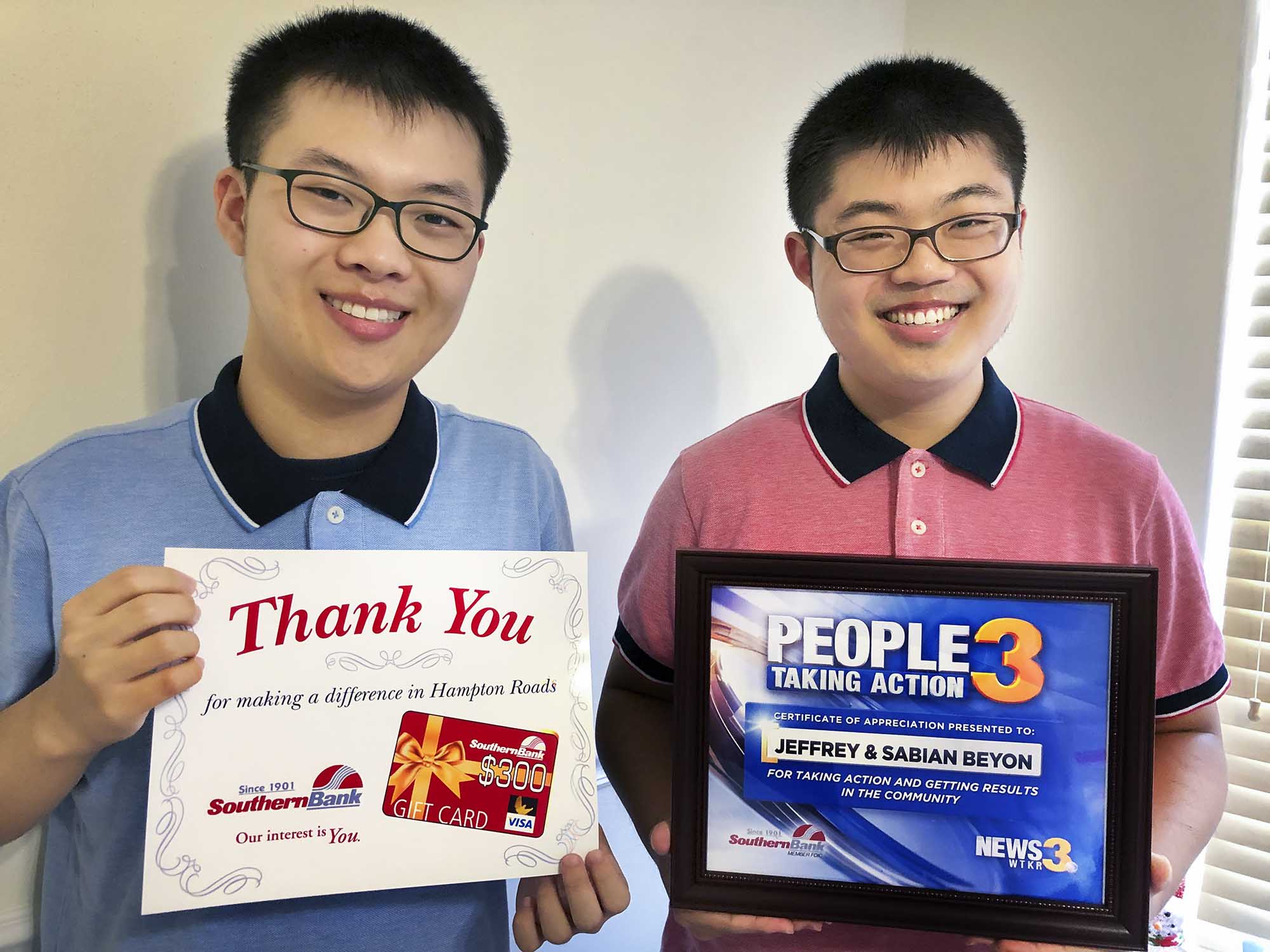 Brothers Sabian and Jeffrey Beyon holding a certificate and a People taking action award plaque