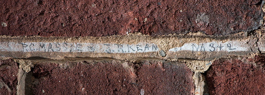 Name written in the mortar of a brick wall  