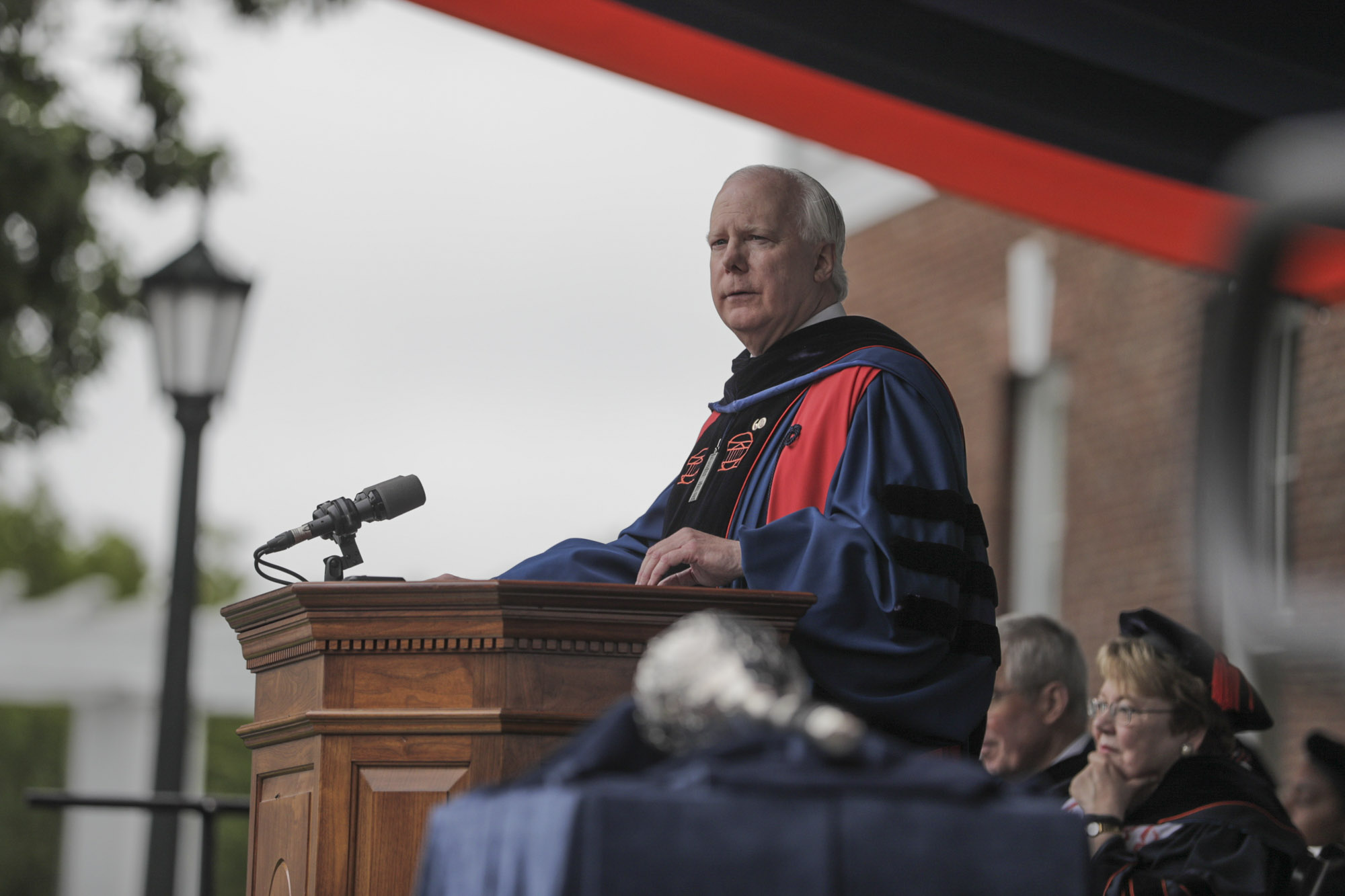 Man speaking at a podium during graduation