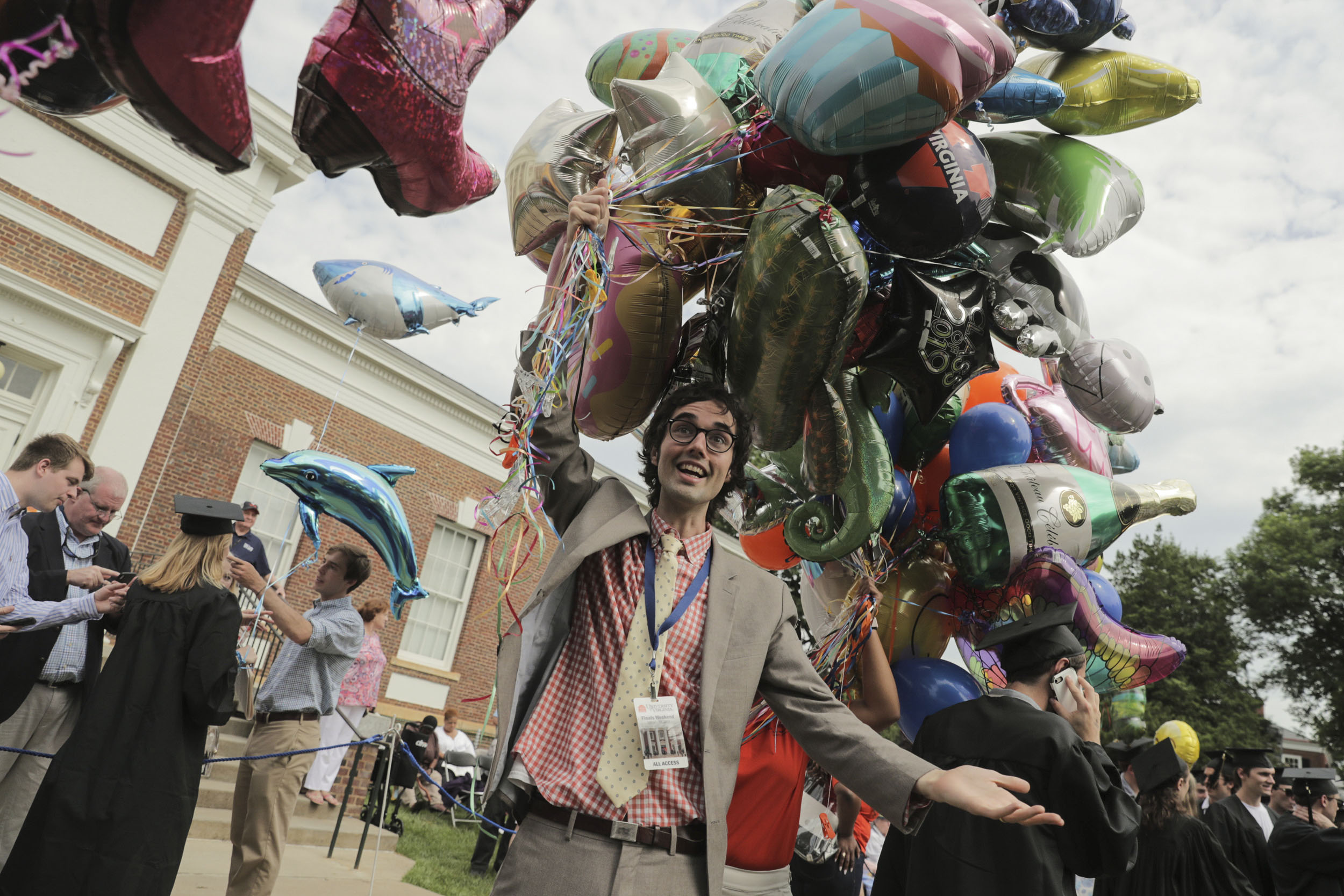 Matt Weber collecting balloons from graduates after their ceremony