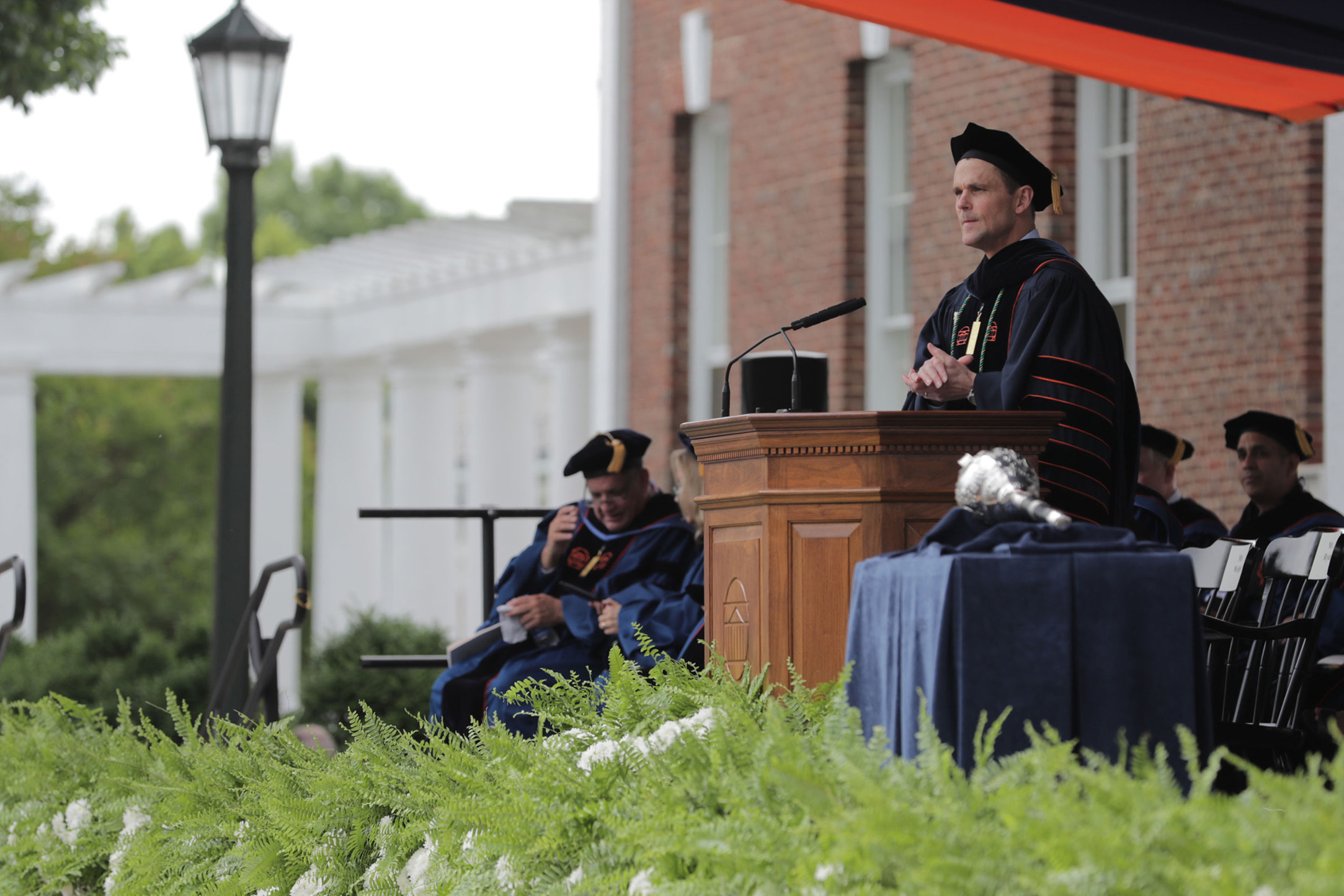 Jim Ryan standing a podium giving a speech during graduation