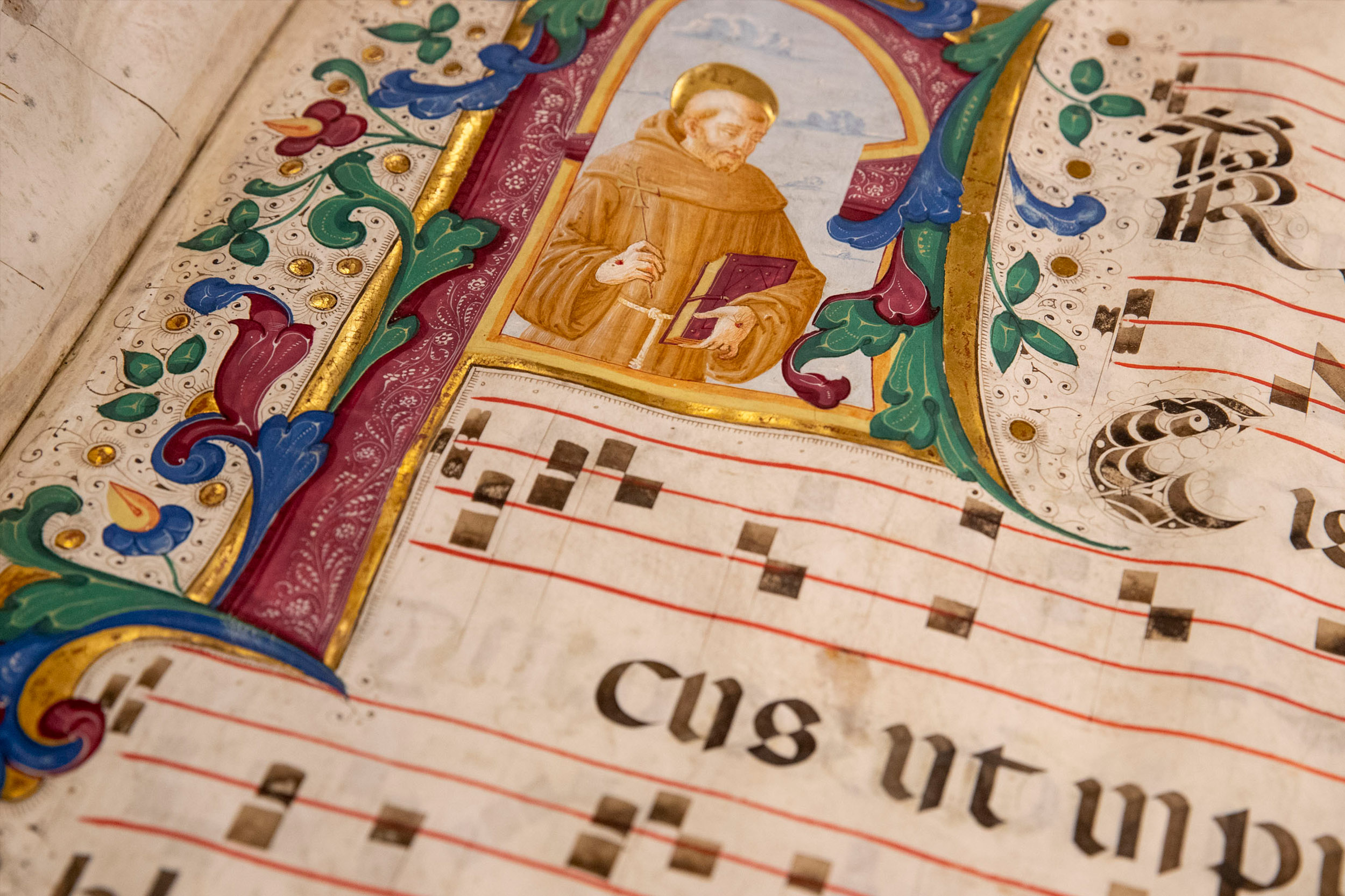 Up close view of an illustration of a monk holding a book 
