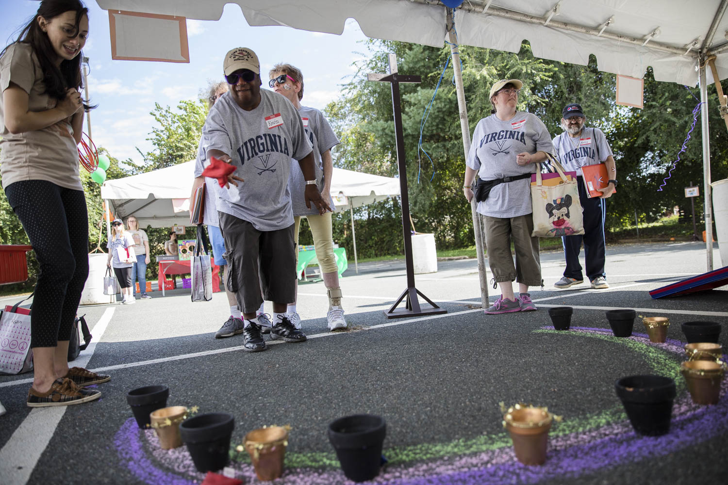 Staff members throw bean bags to small flower pots