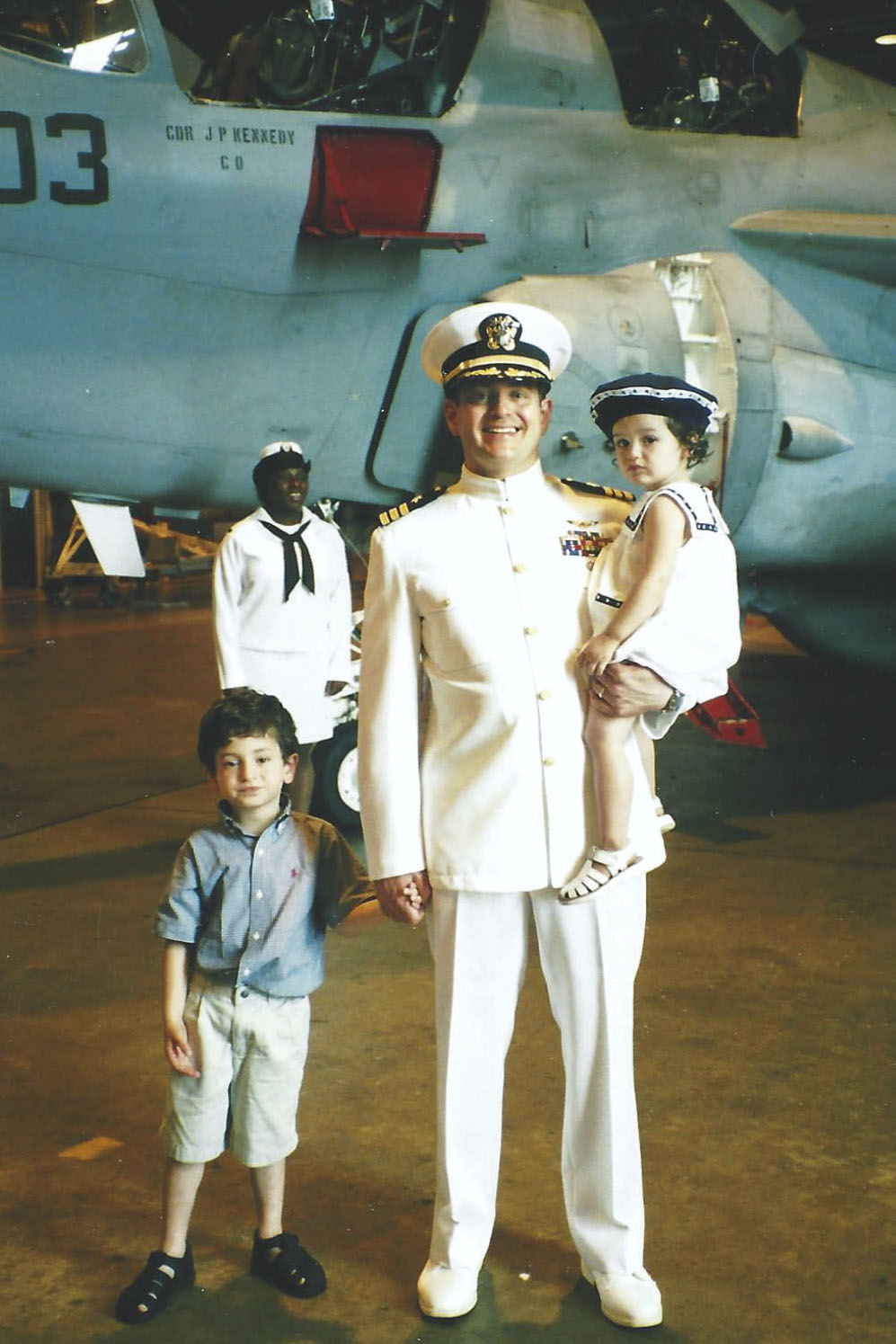 Steve Milone with his two children in front of an airplane while in his Navy Univorm