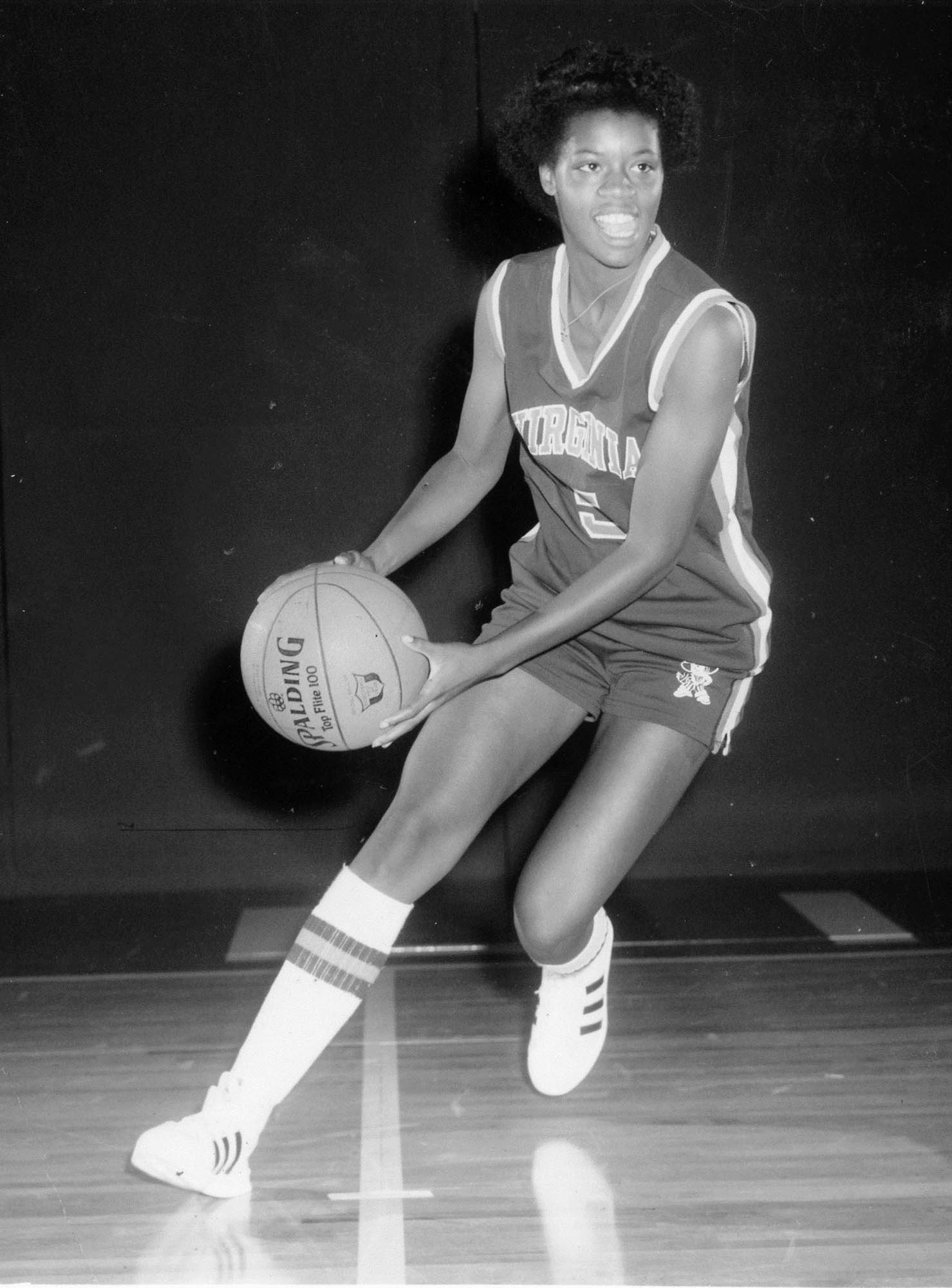 Stroman dribbling a basketball on a basketball court in a UVA uniform