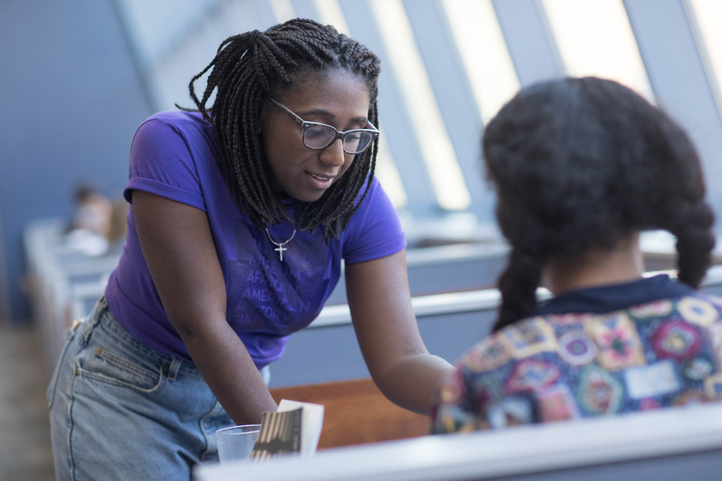 Student helping another student at a table