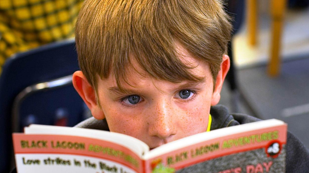 Close up of a child reading a book