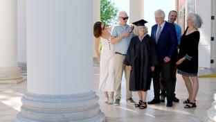 Mary Ann Parr with her cap and gown, surrounded by people