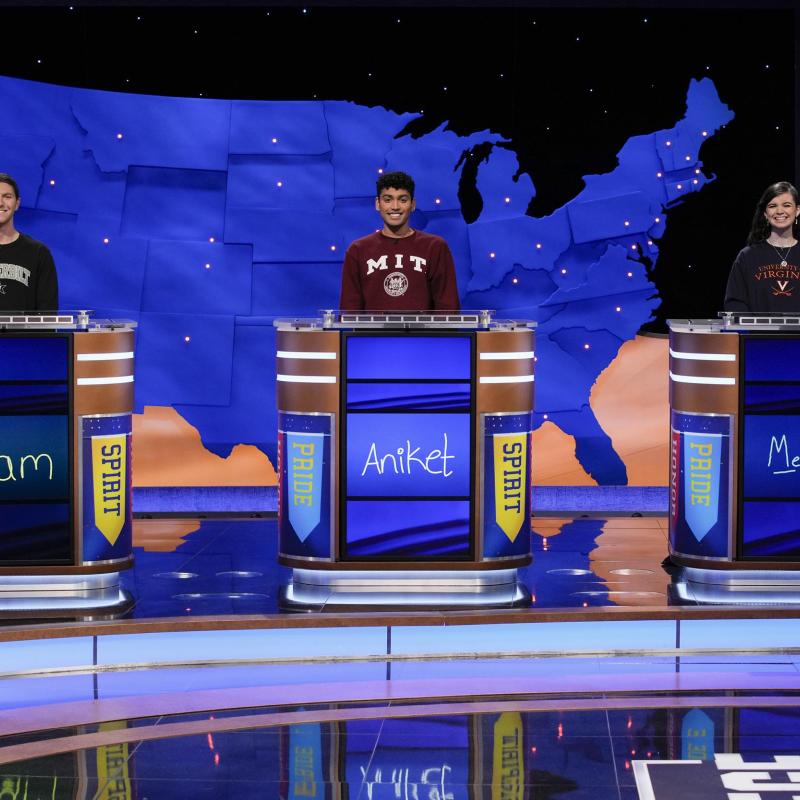 Three college students standing at the jeopardy podiums with UVA's Megan Sullivan on the right
