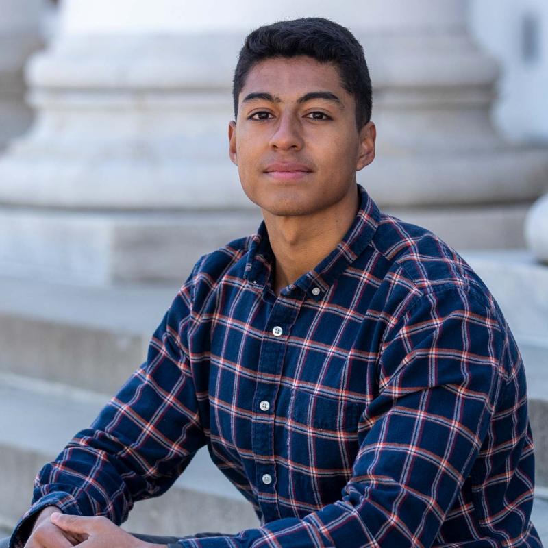 Portrait of Luis Jerez seated on the steps of the UVA Rotunda, confidently facing the camera
