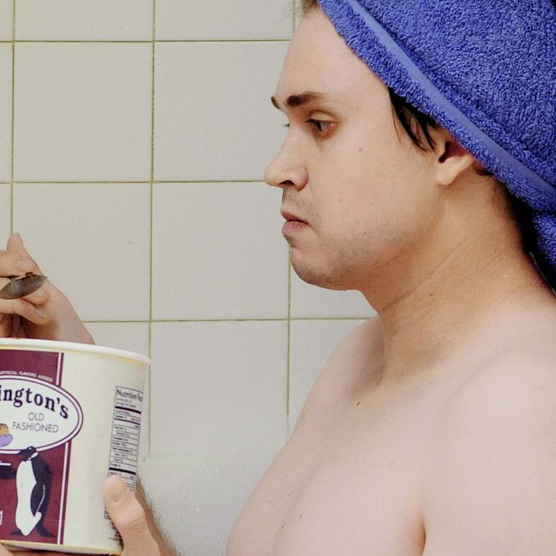 Alex Scheinman sitting in a bathtub eating ice cream during his movie