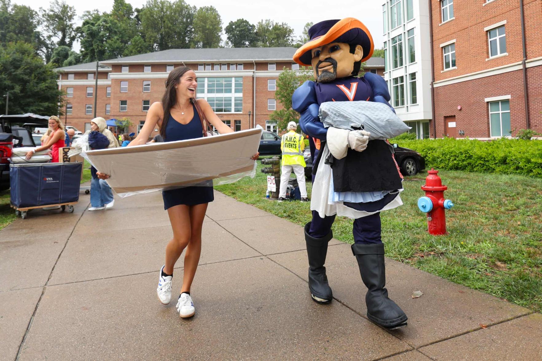 Alexandra Darmanin carrying her belongings to her dorm along with UVA's mascot Cavman