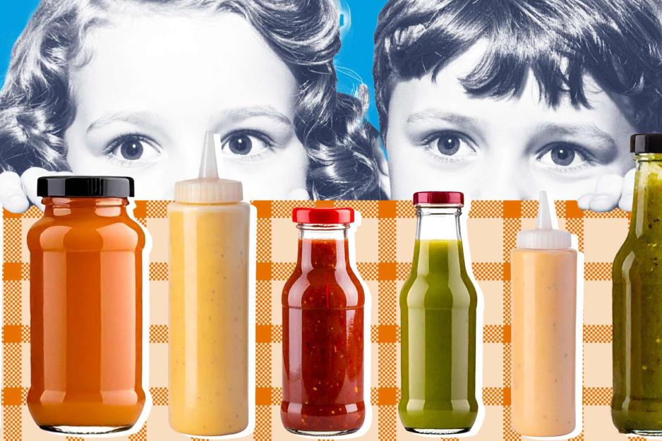Two children looking over the edge of a table at a variety of condiments