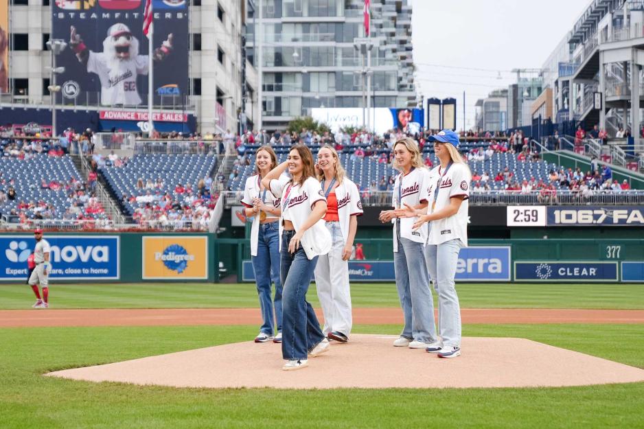 UVA’s Olympic swimmers look on Sunday as fellow decorated Hoo Alex Walsh throws out a ceremonial first pitch at Nationals Park. 