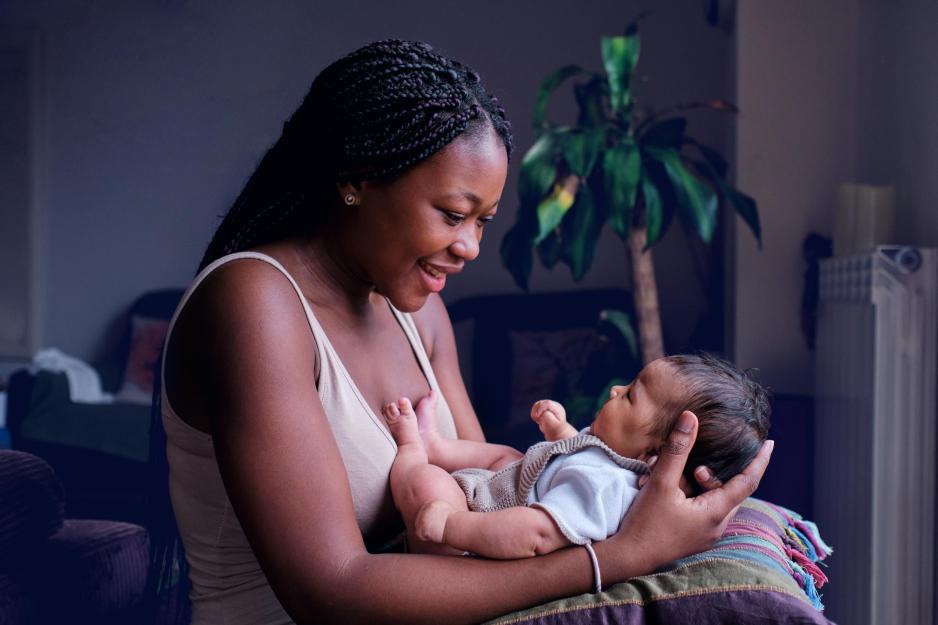 A portrait of a mother holding and gazing at her baby.