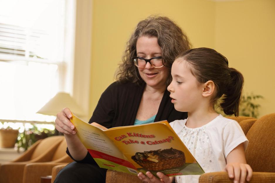 Latisha Hayes reading the book “Can Kittens take a Catnap?” with a young girl