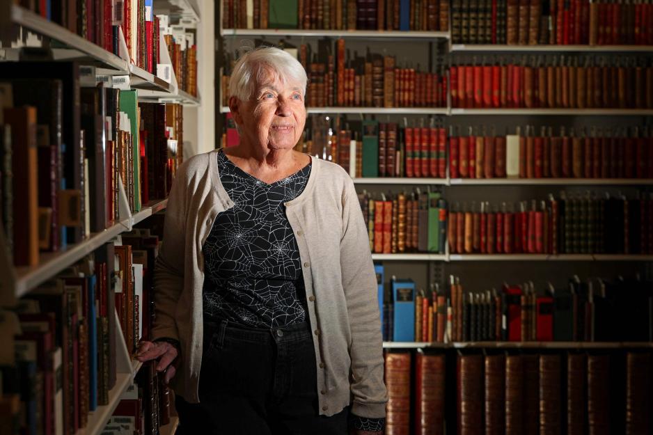 Gayle Cooper standing in a section of books at the UVA Library.