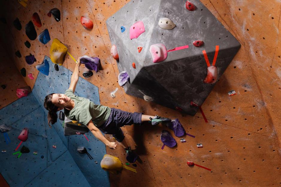 Hannah Zook hanging off the wall and looking at the camera