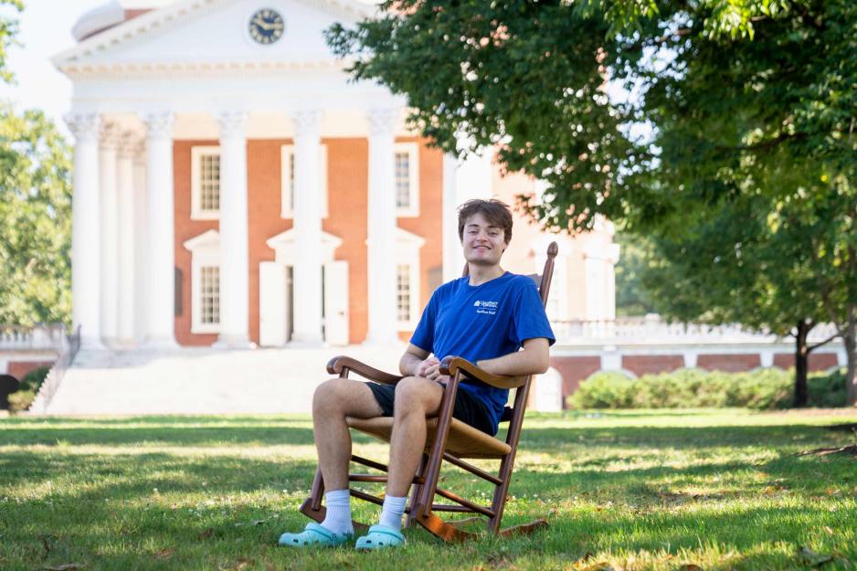 Boris Nakashyan sitting in a rocking chair on the Lawn in front of the UVA Rotunda