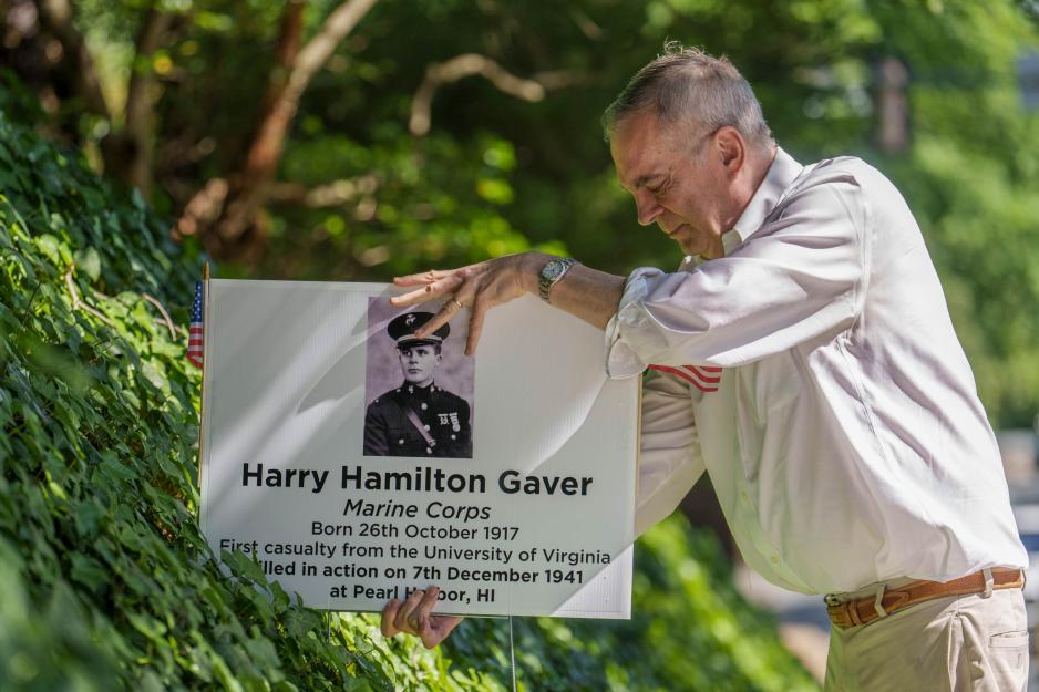 Greg Saathoff placing a yard sign about Harry Hamilton Gaver
