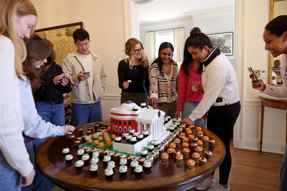 Portrait of UVA Student looking at the Rotunda-shaped cake for the Carr’s Hill Open House.