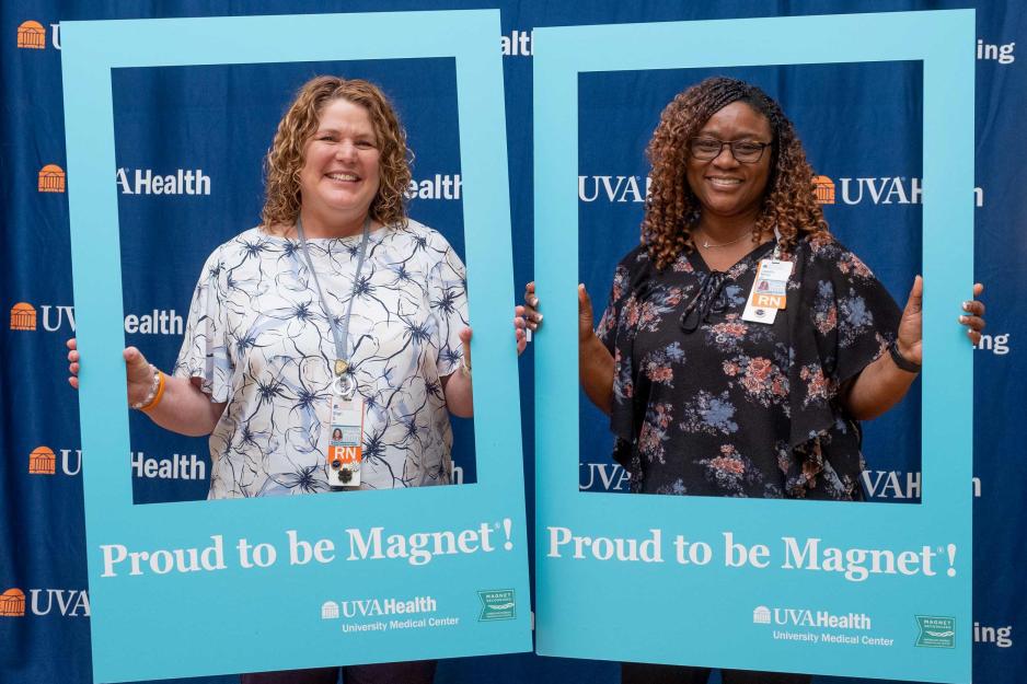 Shari Stanley, left, a nursing governance clinical leader, celebrates with Laquita Minor, a clinical-care director posing with blue cut outs