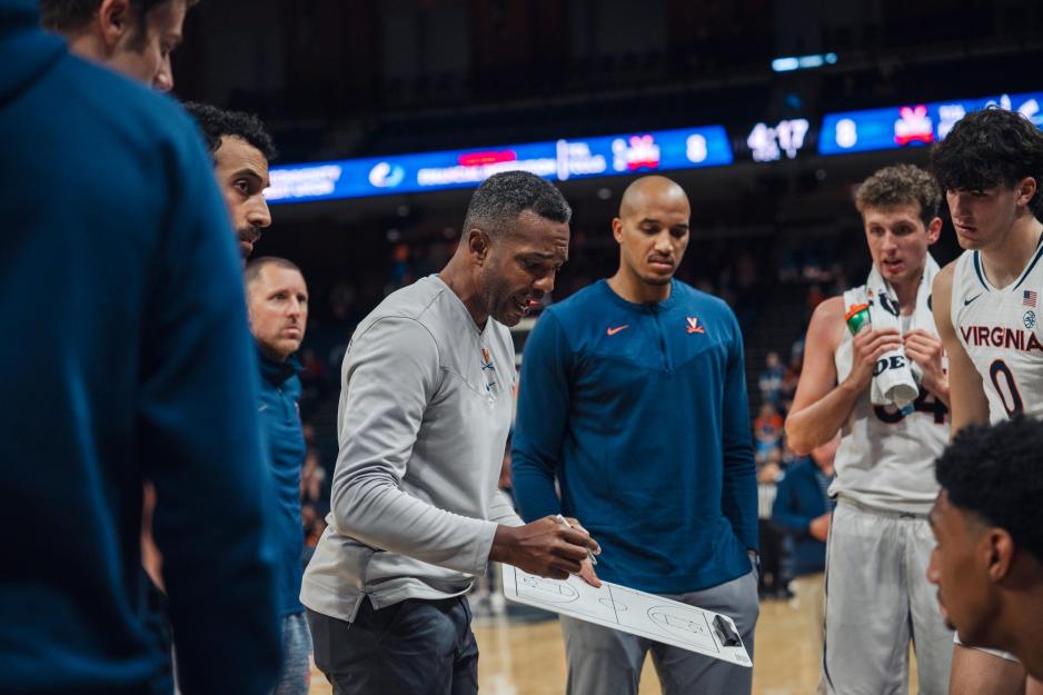 Ron Sanchez giving a strategy talk to the men's basketball team