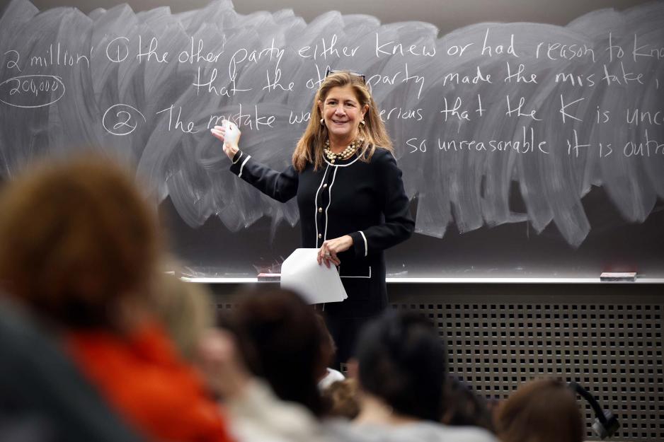 Sherri Moore lecturing in a UVA class gesturing at a chalkboard.